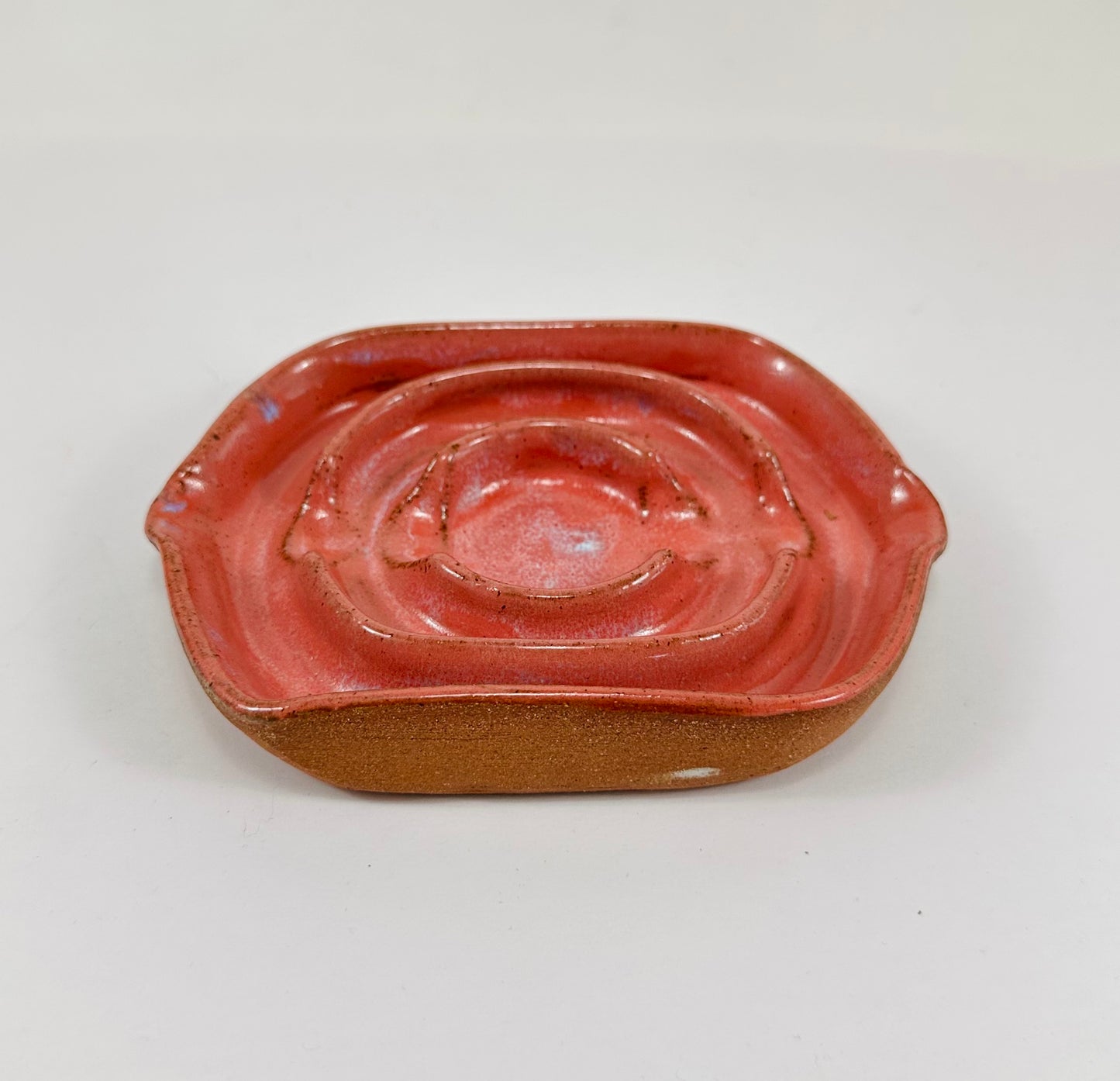A handmade ceramic soap dish in a beautiful pink glaze. The dish is made from red clay.