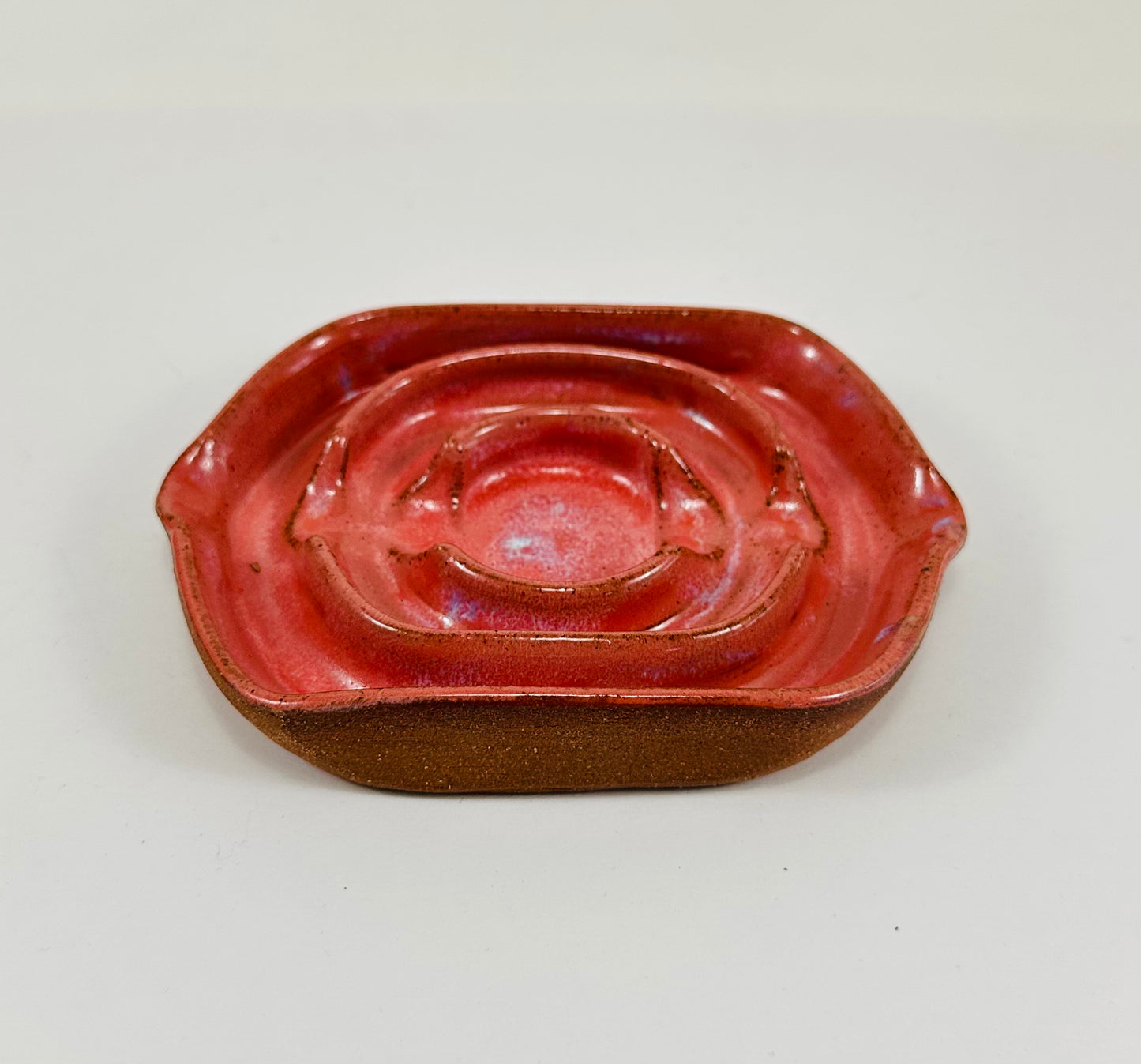 A handmade ceramic soap dish in a beautiful pink glaze. The dish is made from red clay.