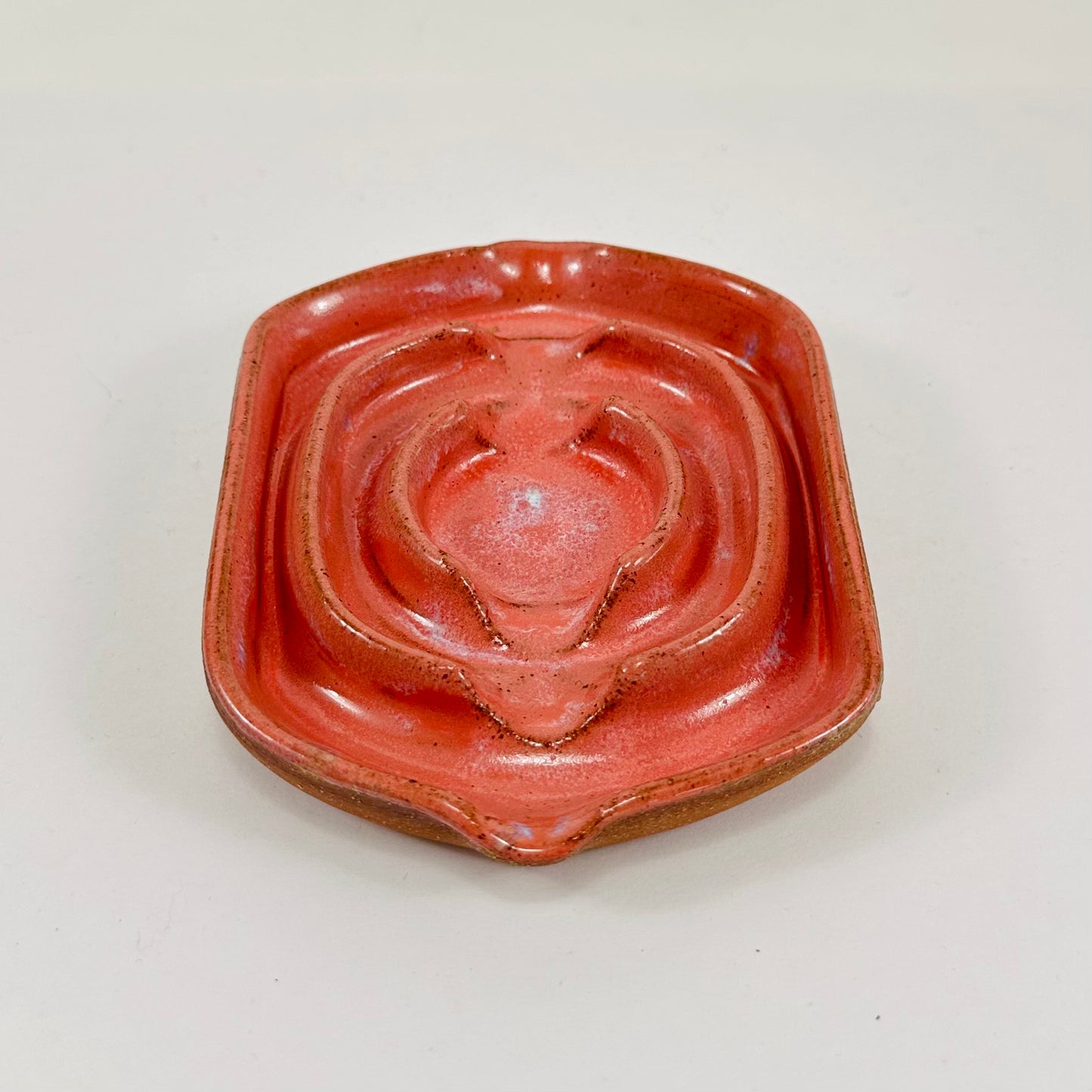 A handmade ceramic soap dish in a beautiful pink glaze. The dish is made from red clay.
