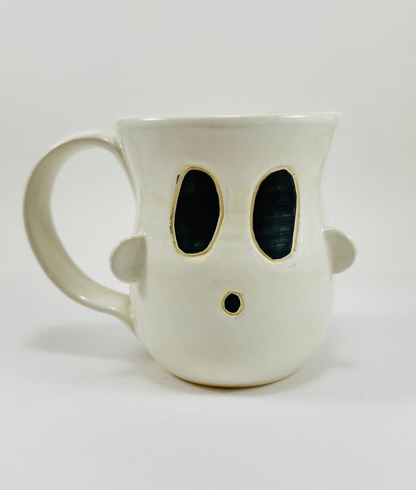 Handmade ceramic ghost mug with white glaze on the outside and purple on the inside.