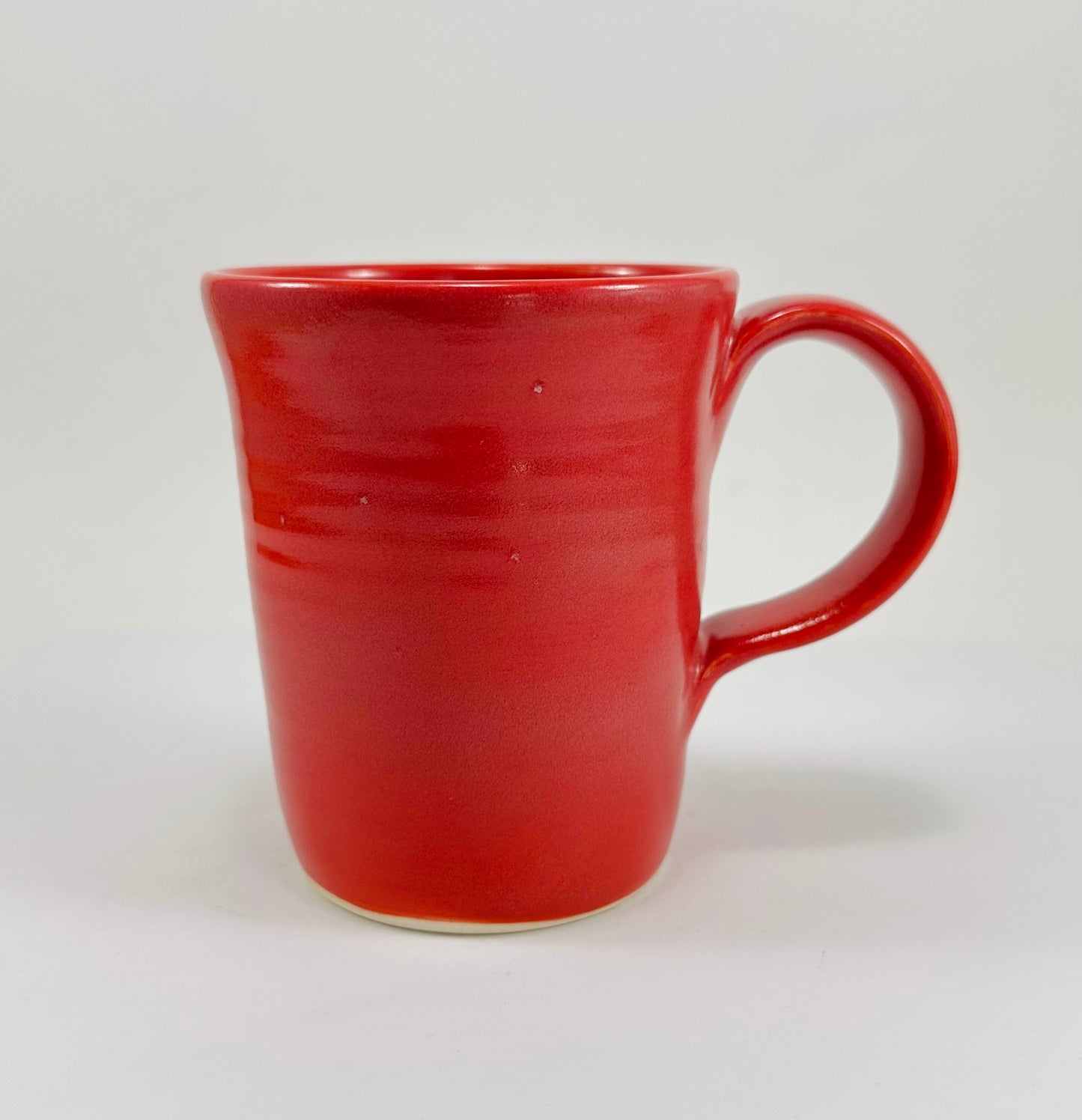 Pink mug with a green frog design on a white background