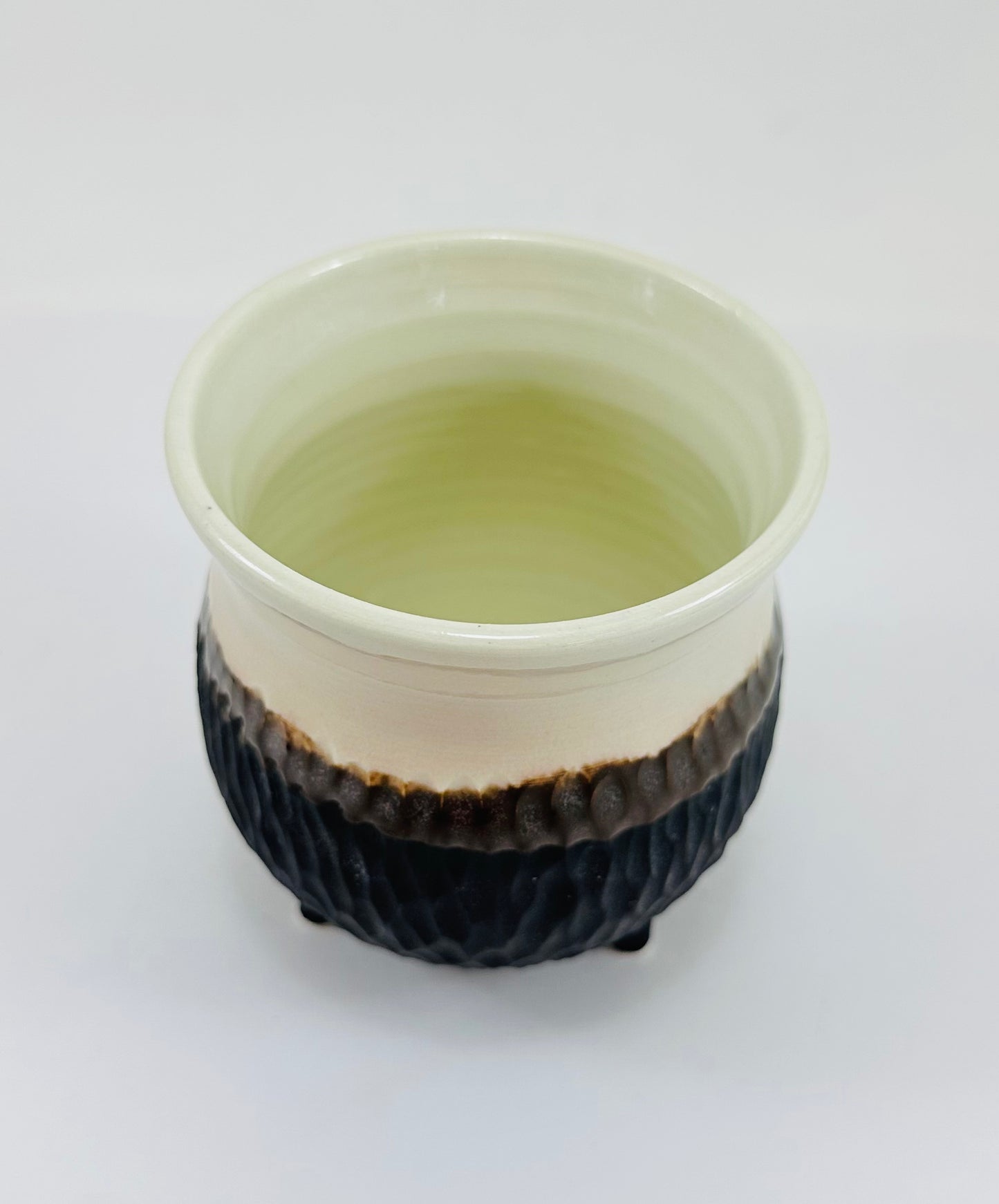 A handmade ceramic cauldron in a beautiful white and brown glaze.