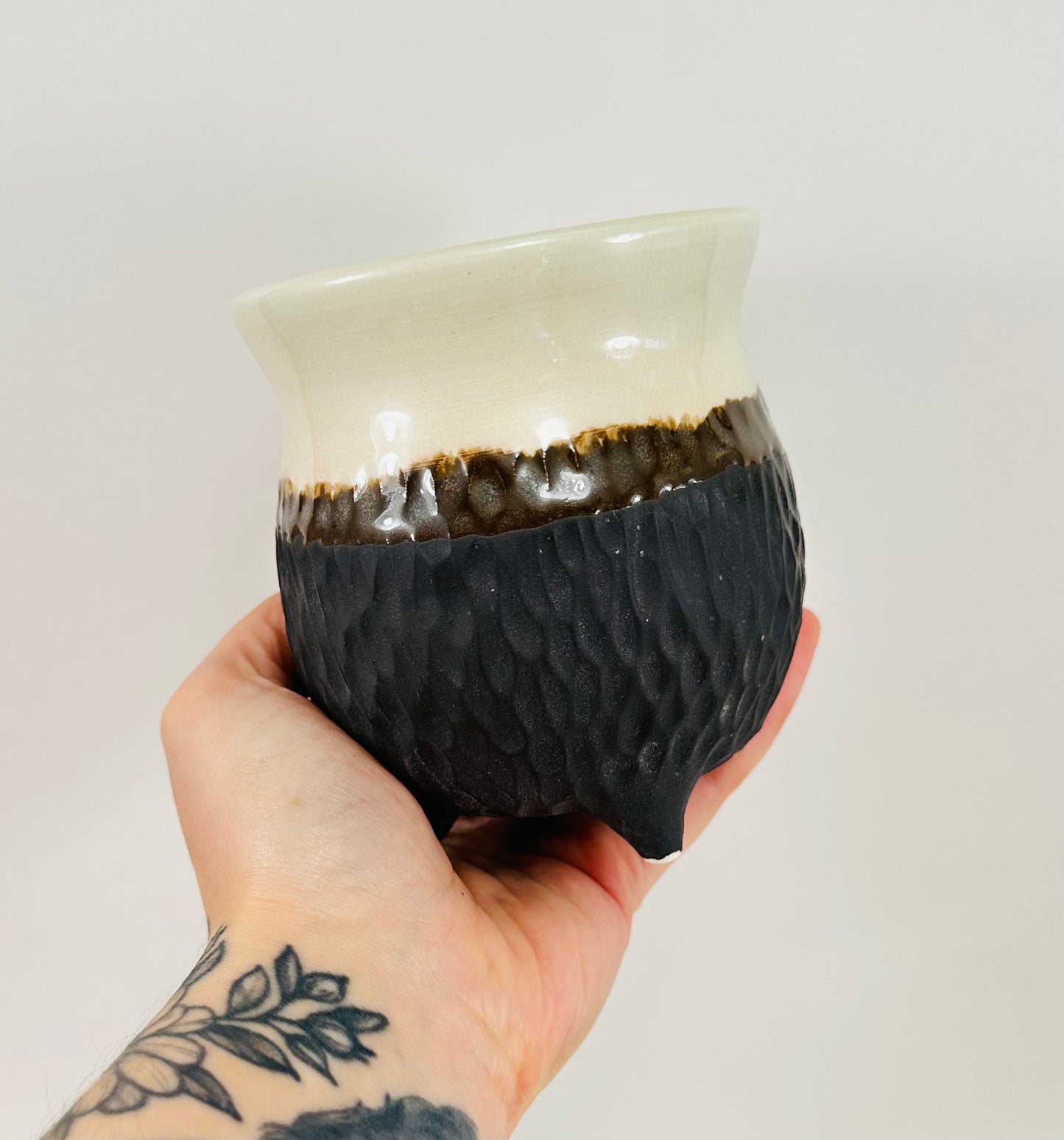 A handmade ceramic cauldron in a beautiful white and brown glaze.