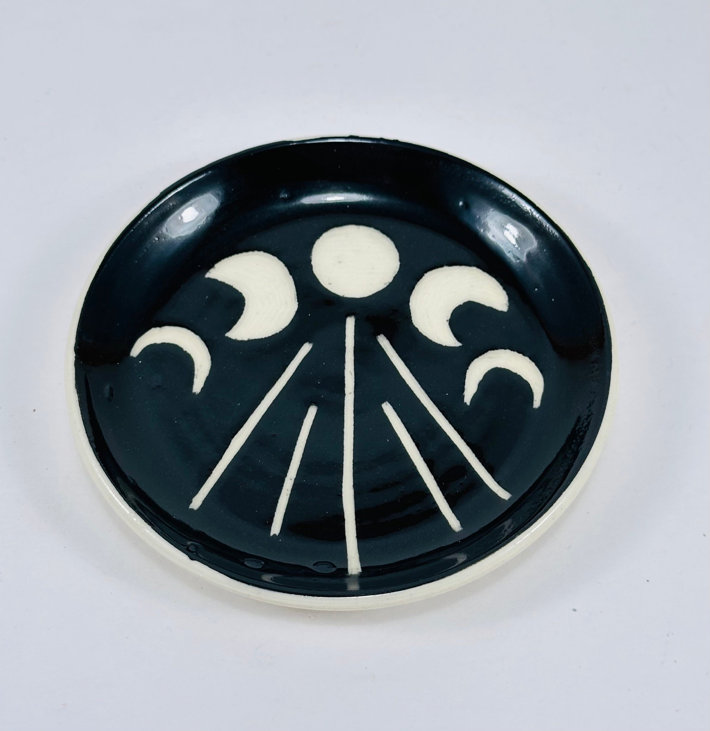 Handmade trinket dish in black and white glaze with moons.