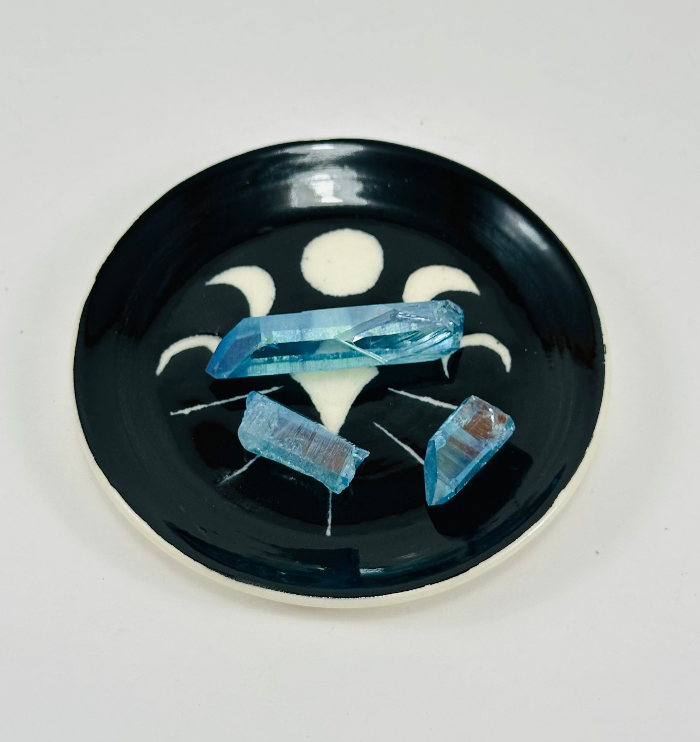 Handmade trinket dish in black and white glaze with moons and stars.