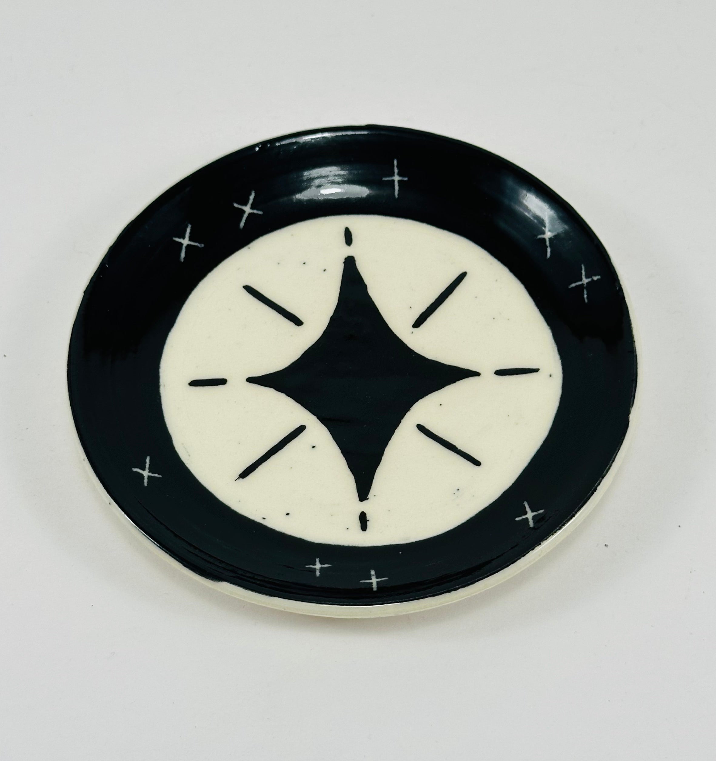 Handmade trinket dish in black and white glaze with stars.