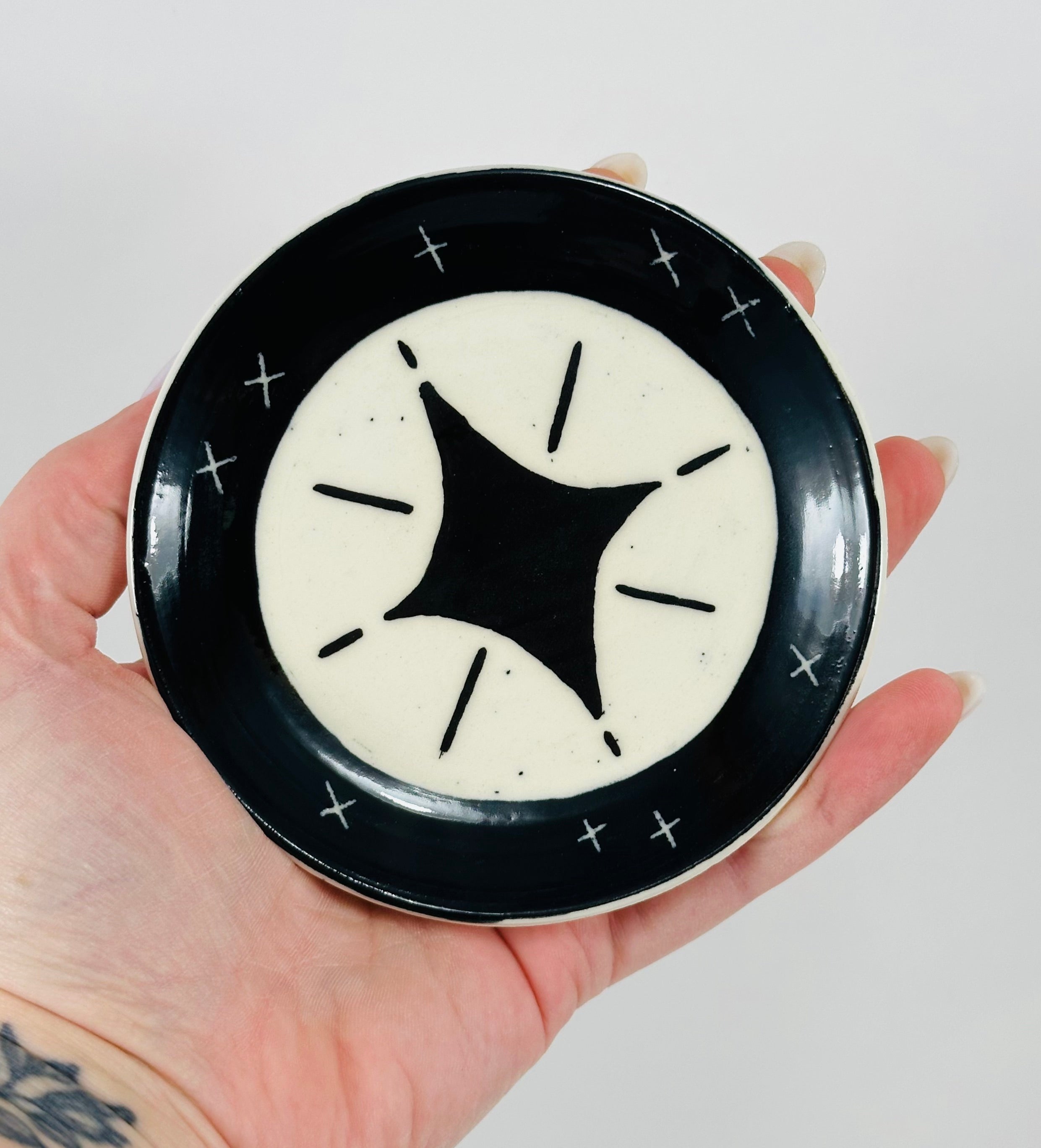 Handmade trinket dish in black and white glaze with stars.