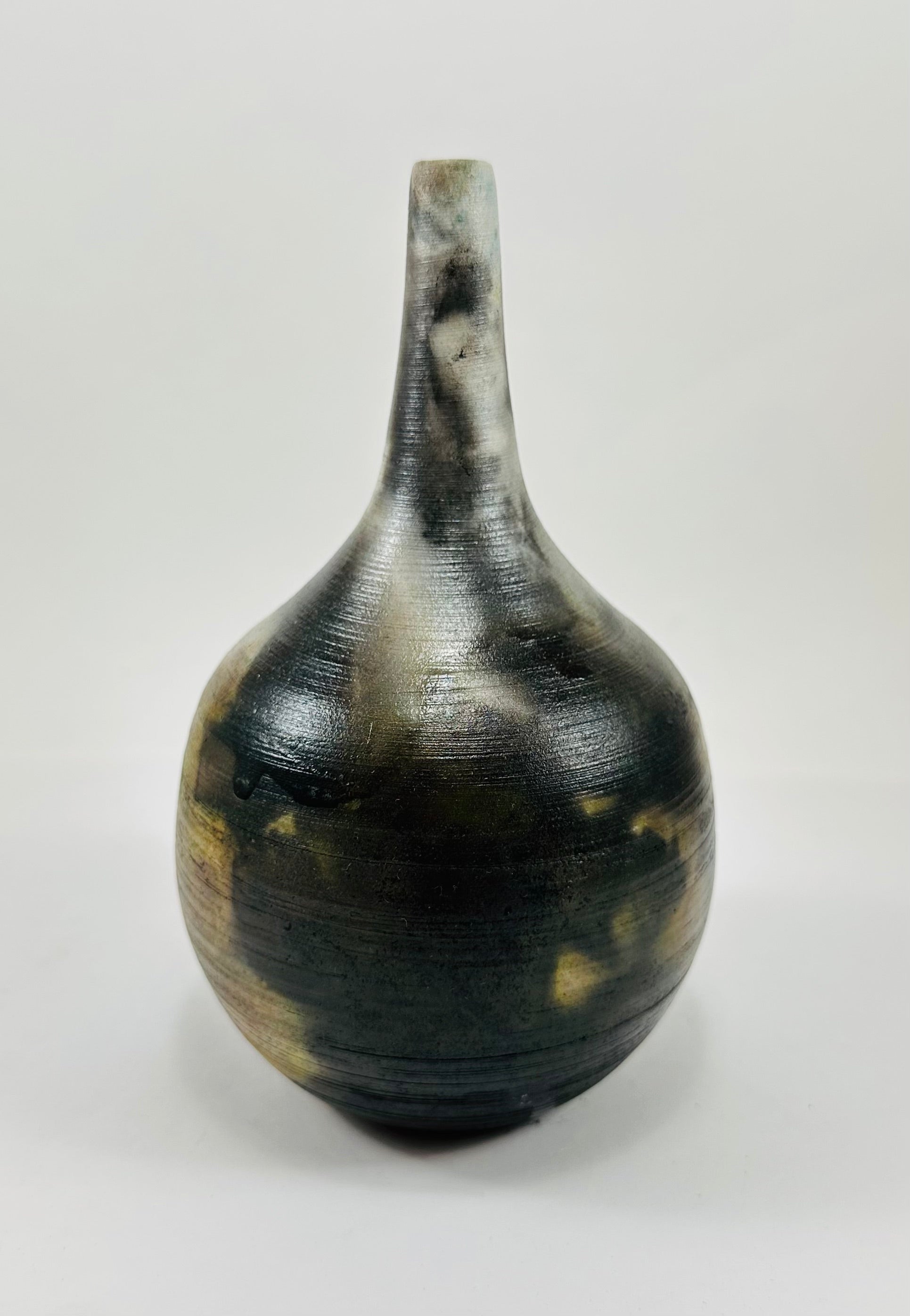 Handmade, skinny neck vase with a brown, white, black and yellow smokey finish.