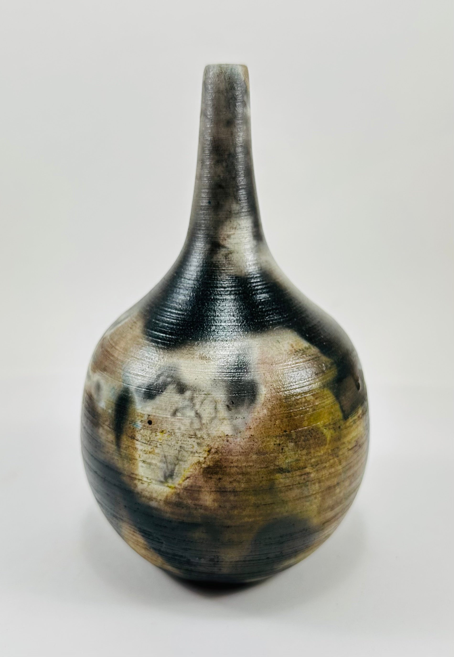 Handmade, skinny neck vase with a brown, white, black and yellow smokey finish.
