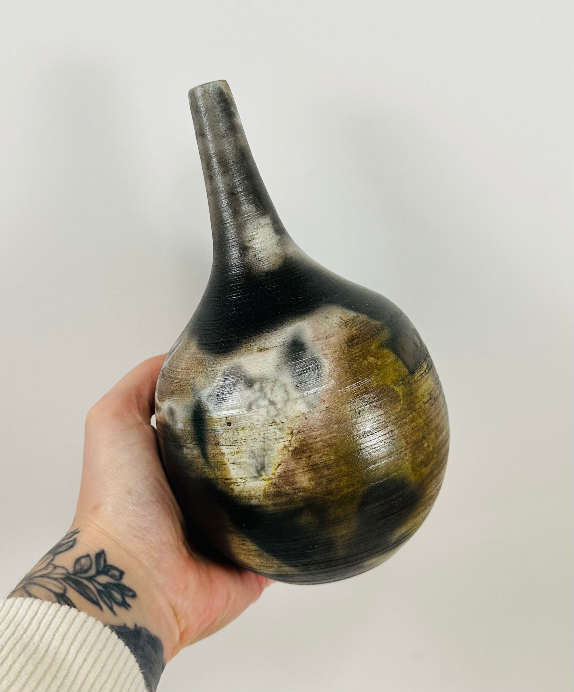 Handmade, skinny neck vase with a brown, white, black and yellow smokey finish.