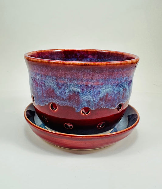A handmade ceramic berry bowl glazed in a beautiful red and blue drip glaze. The berry bowl comes with a matching ceramic plate to catch water. It is made from porcelain clay.