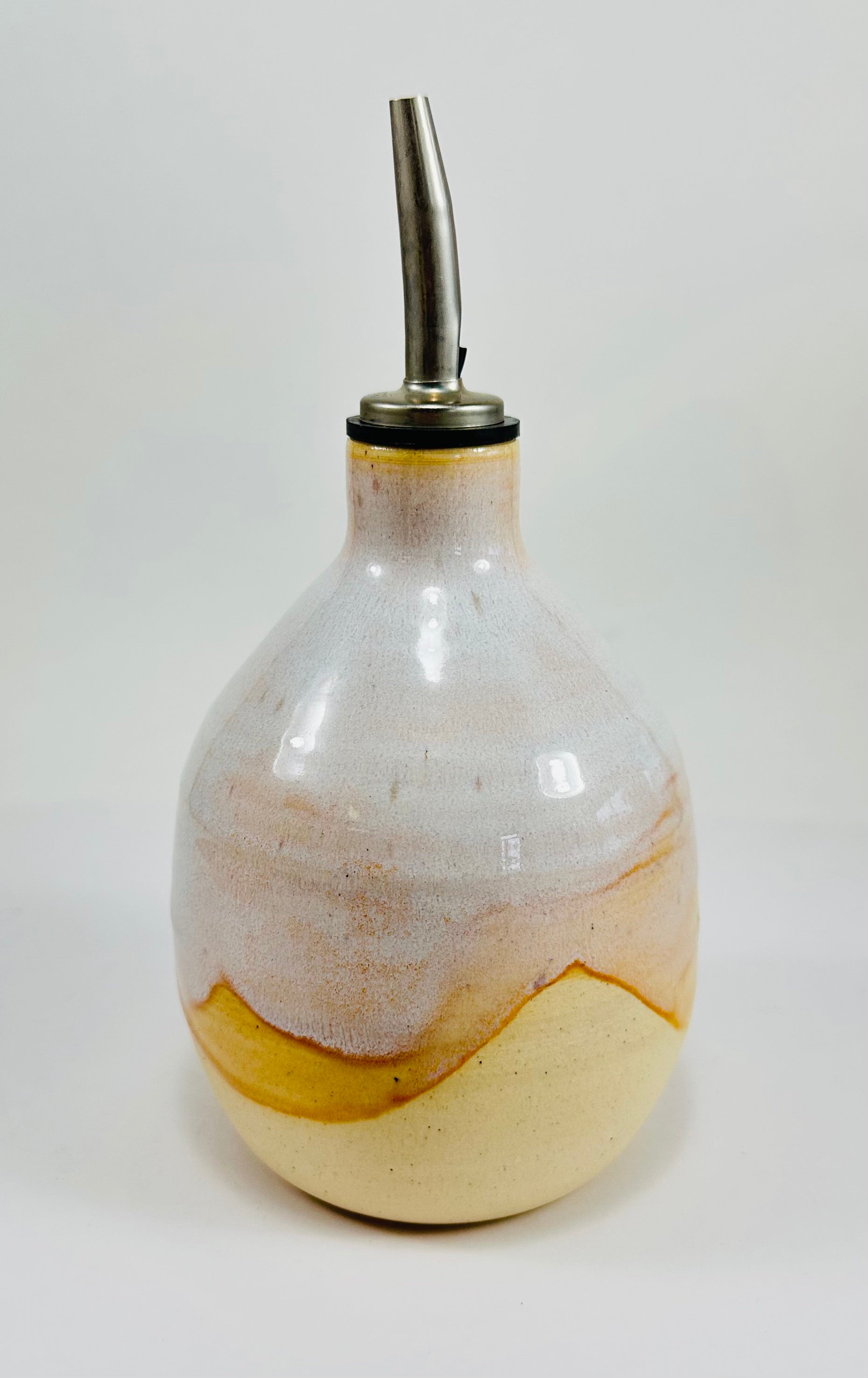 A handmade ceramic oil decanter glazed in a beautiful cream and brown on red clay.