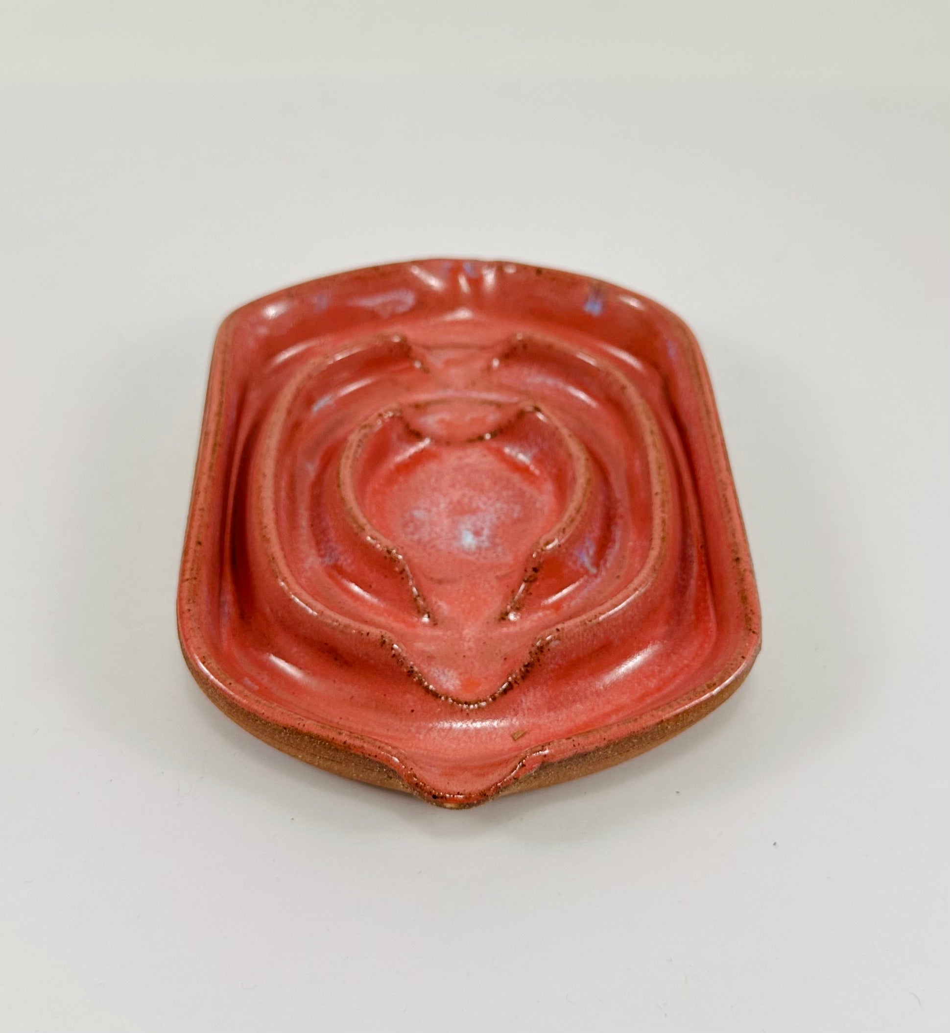 A handmade ceramic soap dish in a beautiful pink glaze. The dish is made from red clay.