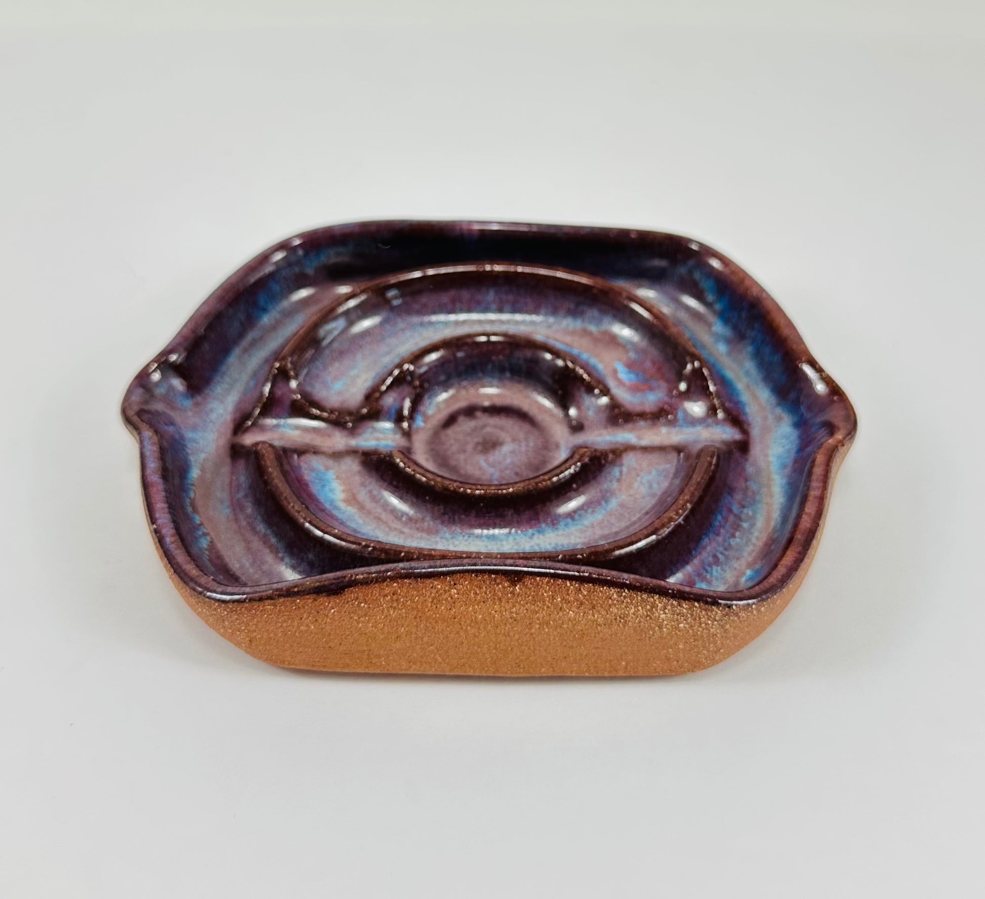 A handmade ceramic soap dish in a beautiful purple glaze. The dish is made from red clay.