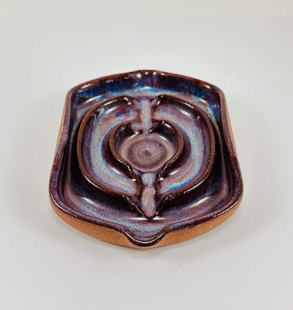A handmade ceramic soap dish in a beautiful purple glaze. The dish is made from red clay.