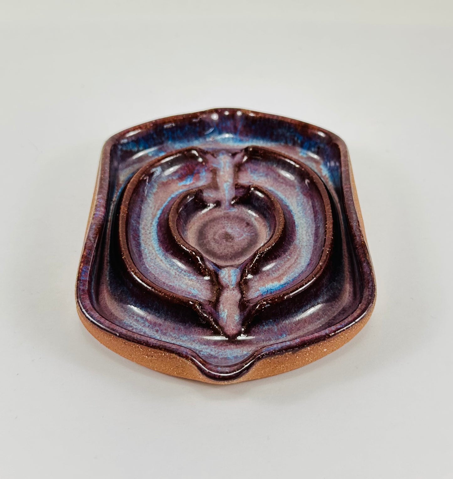 A handmade ceramic soap dish in a beautiful purple glaze. The dish is made from red clay.
