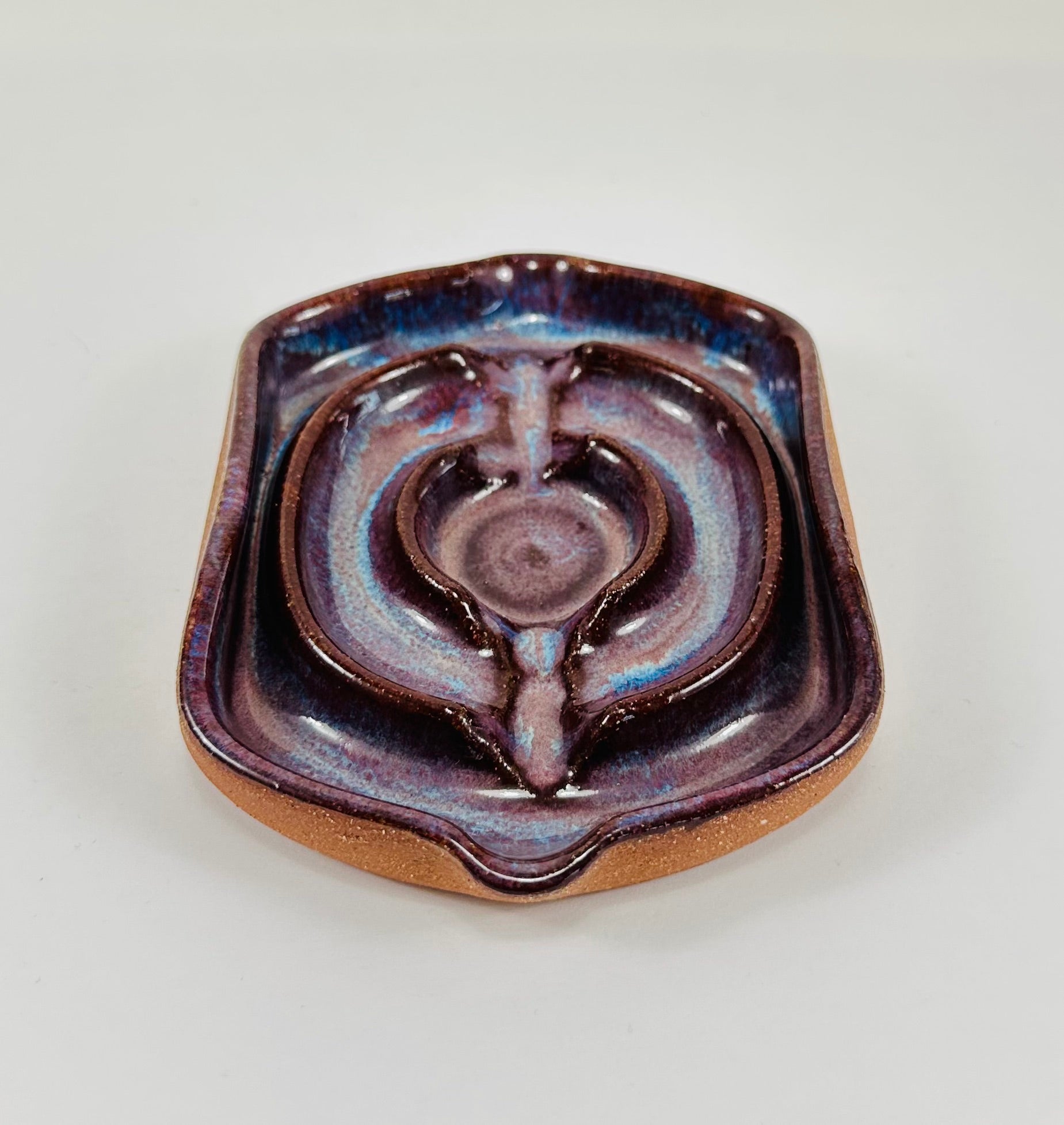 A handmade ceramic soap dish in a beautiful purple glaze. The dish is made from red clay.