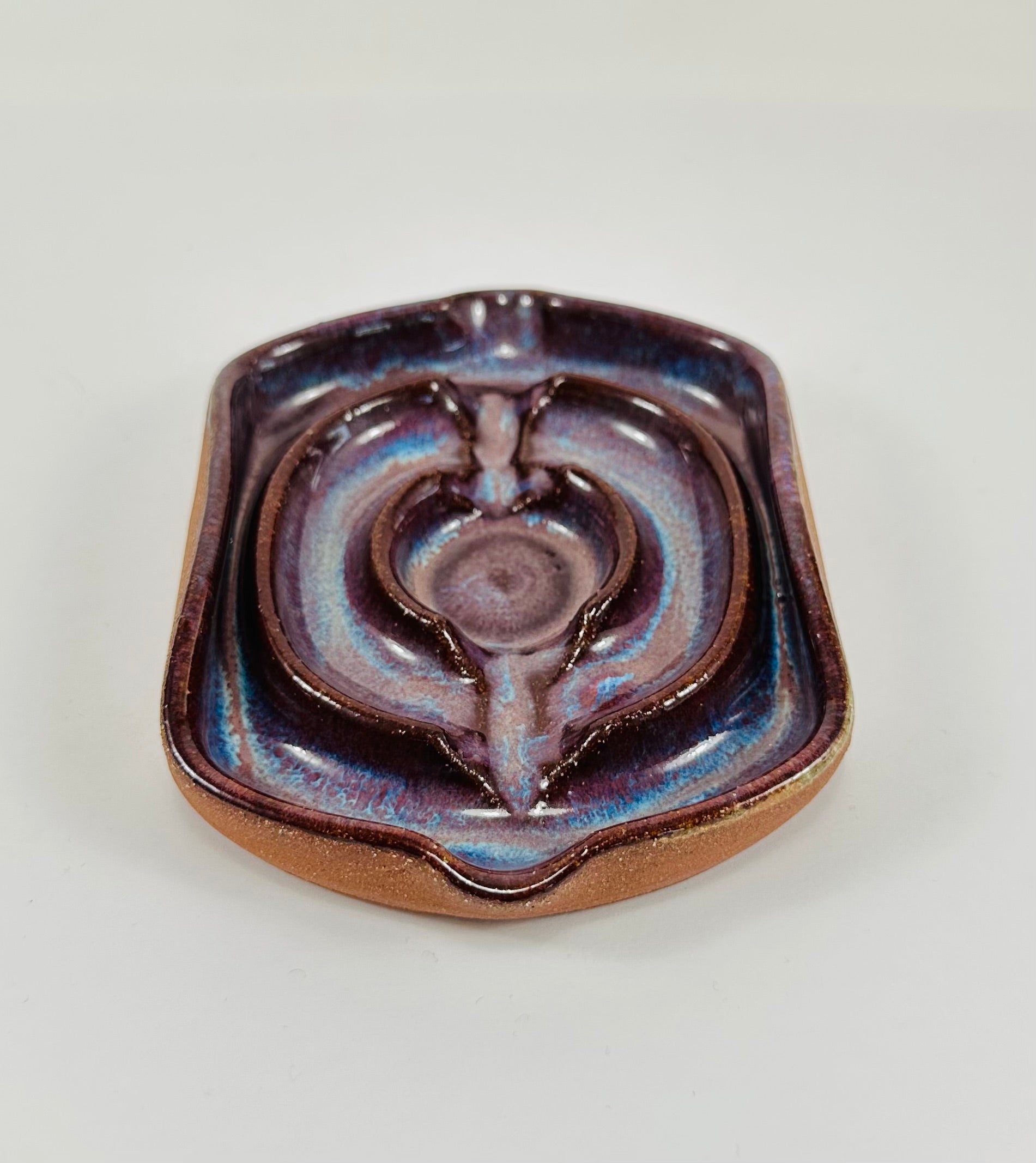 A handmade ceramic soap dish in a beautiful purple glaze. The dish is made from red clay.