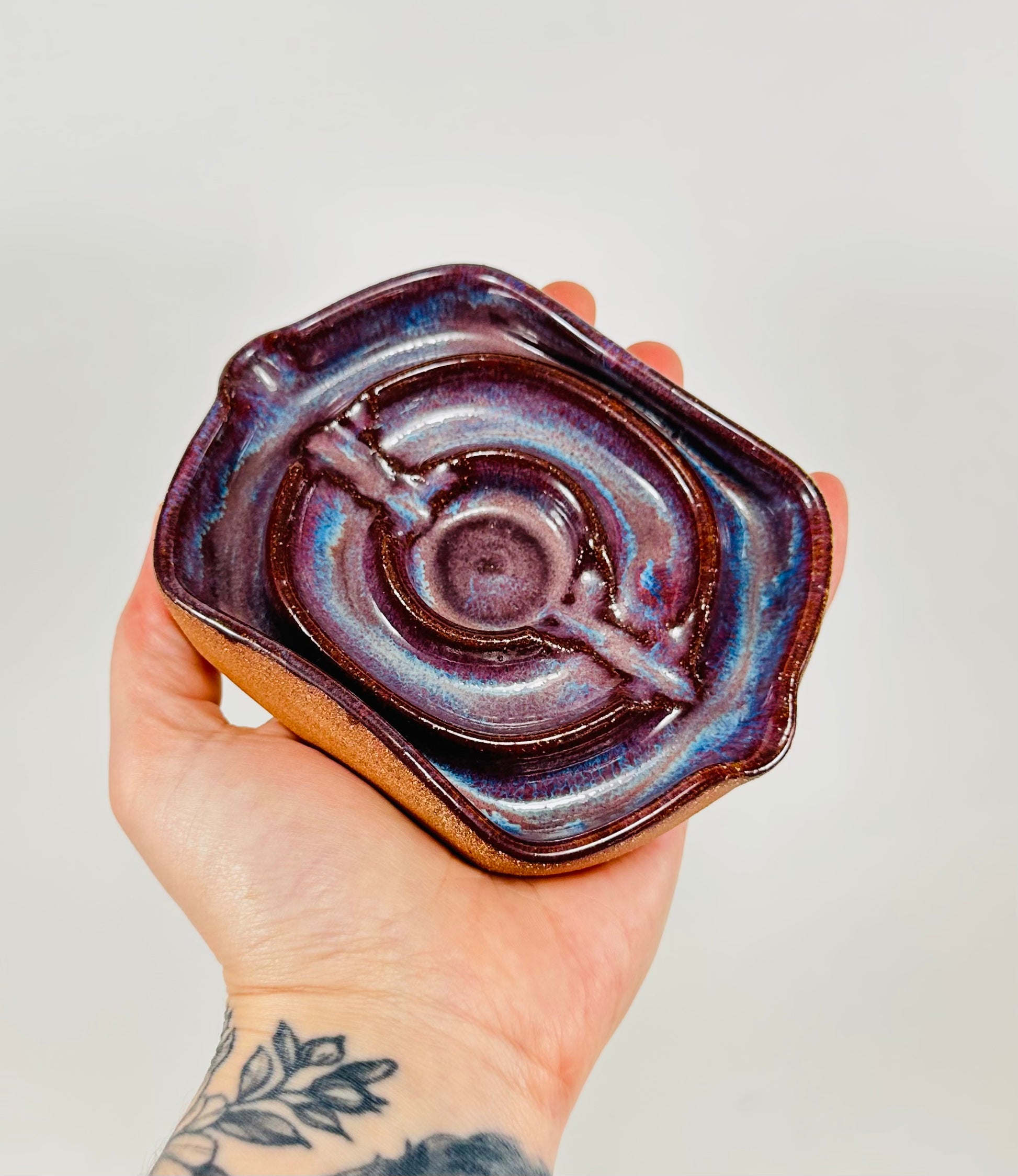 A handmade ceramic soap dish in a beautiful purple glaze. The dish is made from red clay.