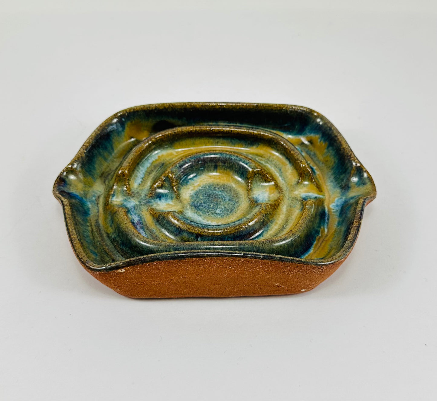 A handmade ceramic soap dish in a beautiful green glaze. The dish is made from red clay.
