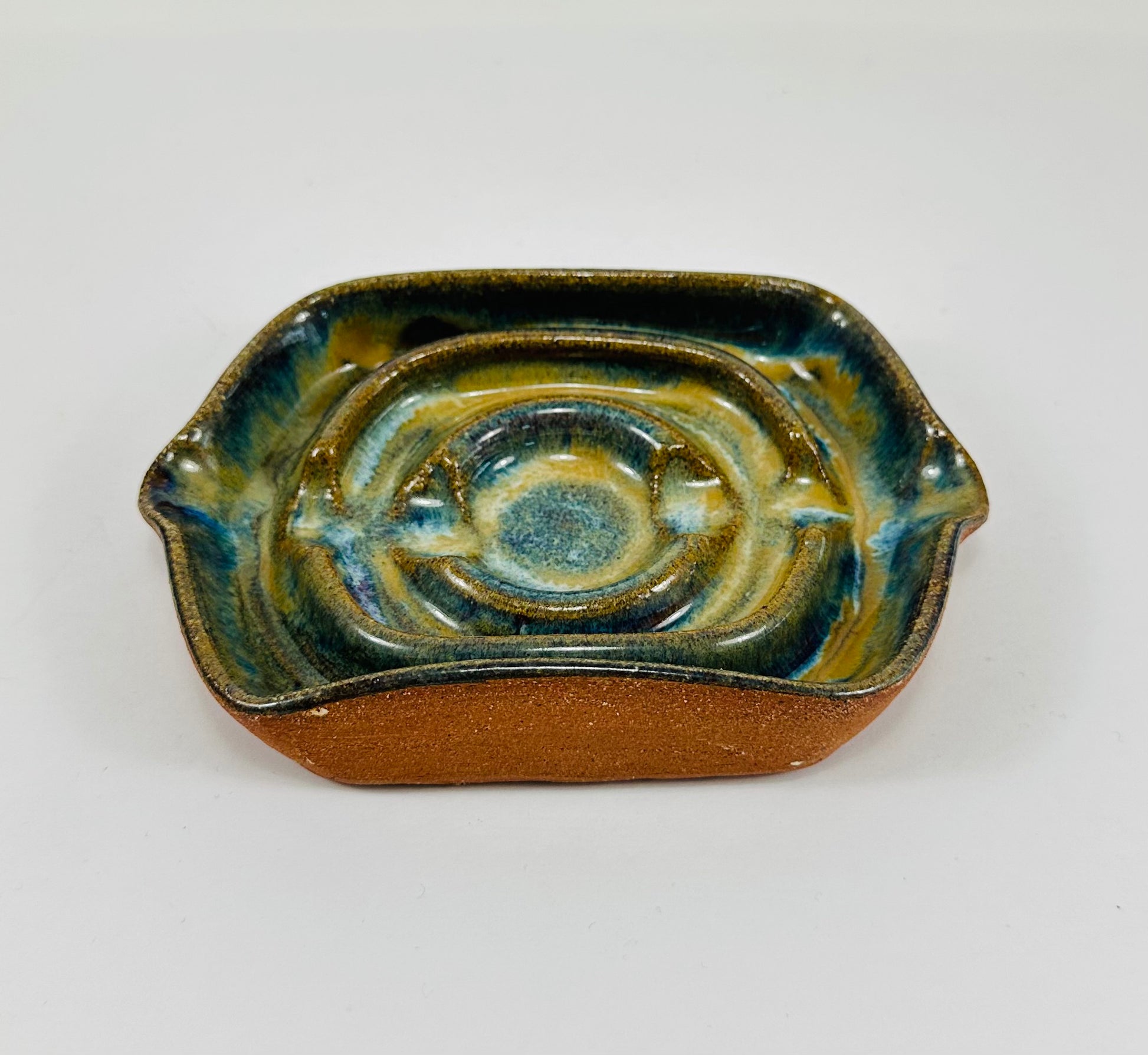 A handmade ceramic soap dish in a beautiful green glaze. The dish is made from red clay.