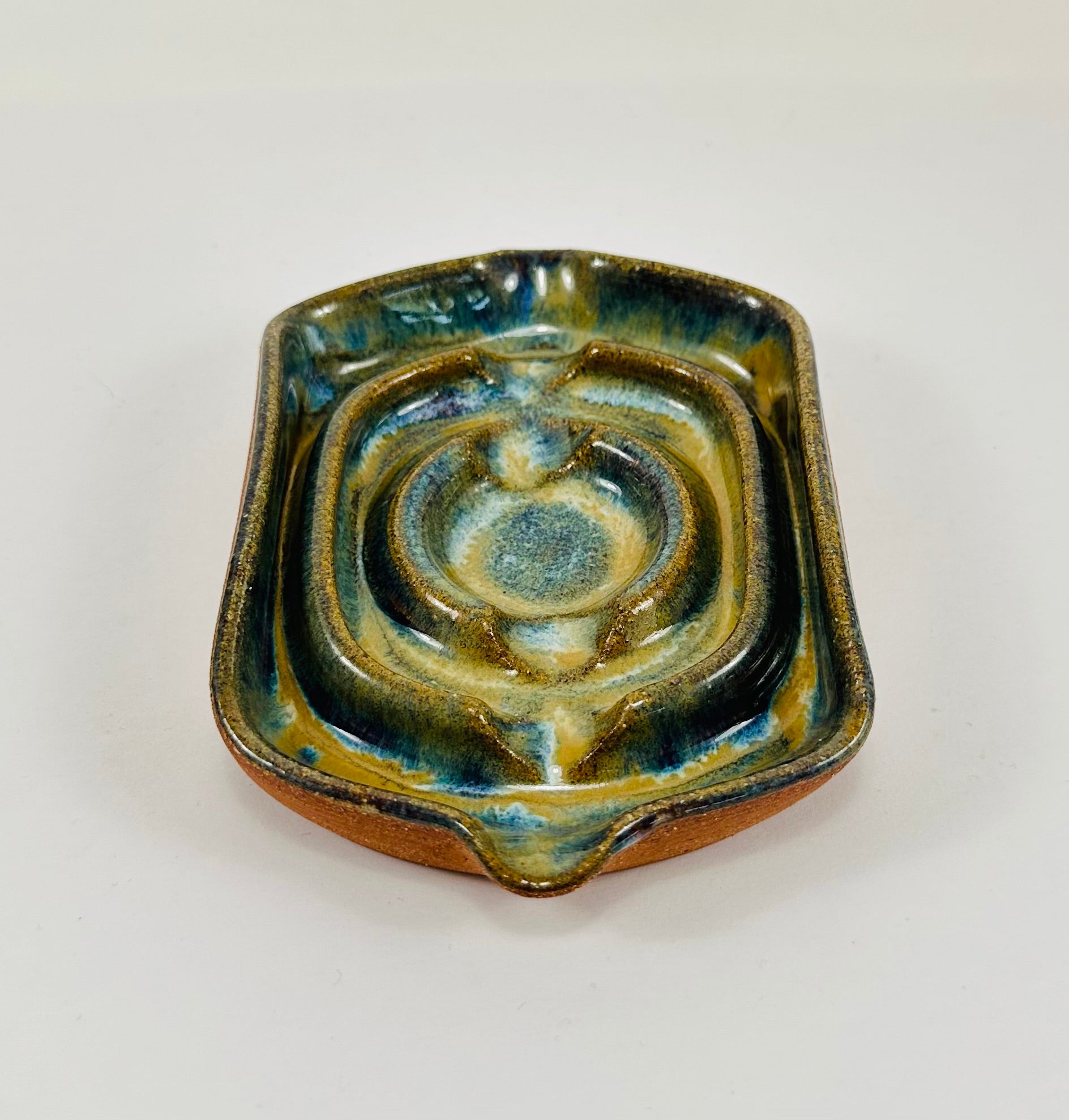 A handmade ceramic soap dish in a beautiful green glaze. The dish is made from red clay.