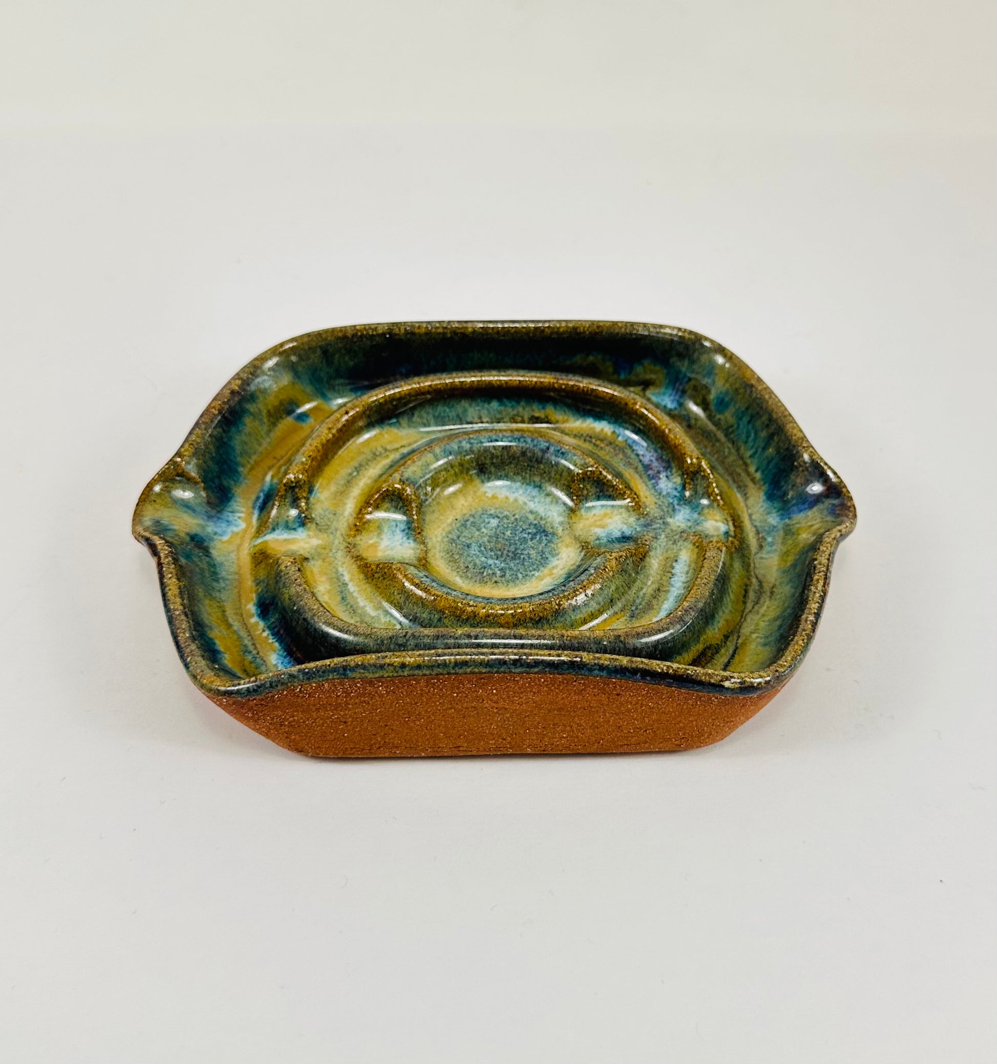 A handmade ceramic soap dish in a beautiful green glaze. The dish is made from red clay.