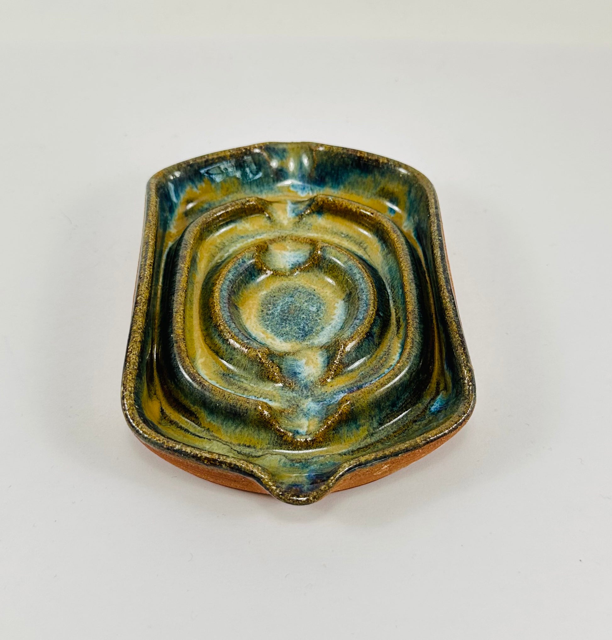 A handmade ceramic soap dish in a beautiful green glaze. The dish is made from red clay.