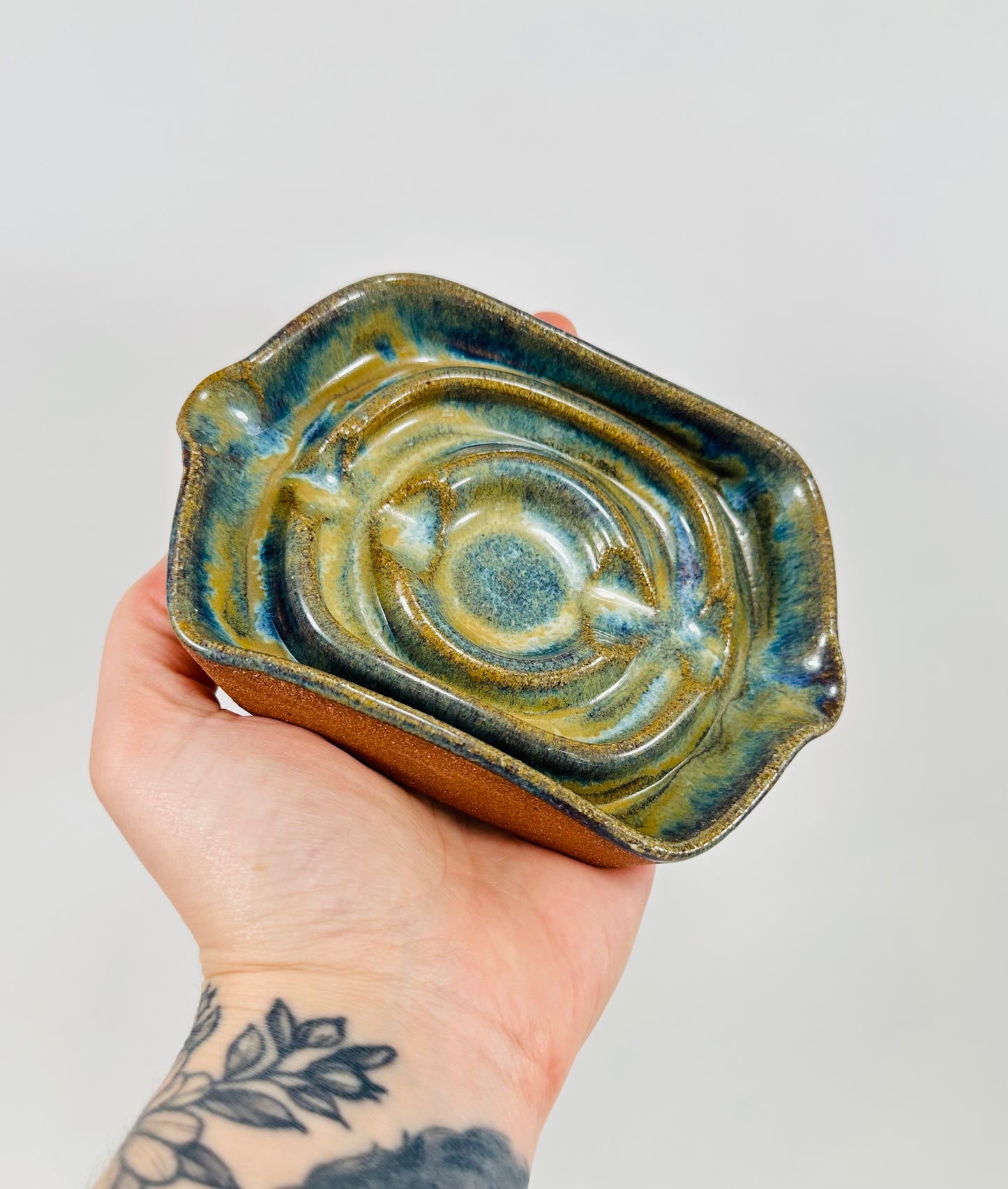 A handmade ceramic soap dish in a beautiful green glaze. The dish is made from red clay.
