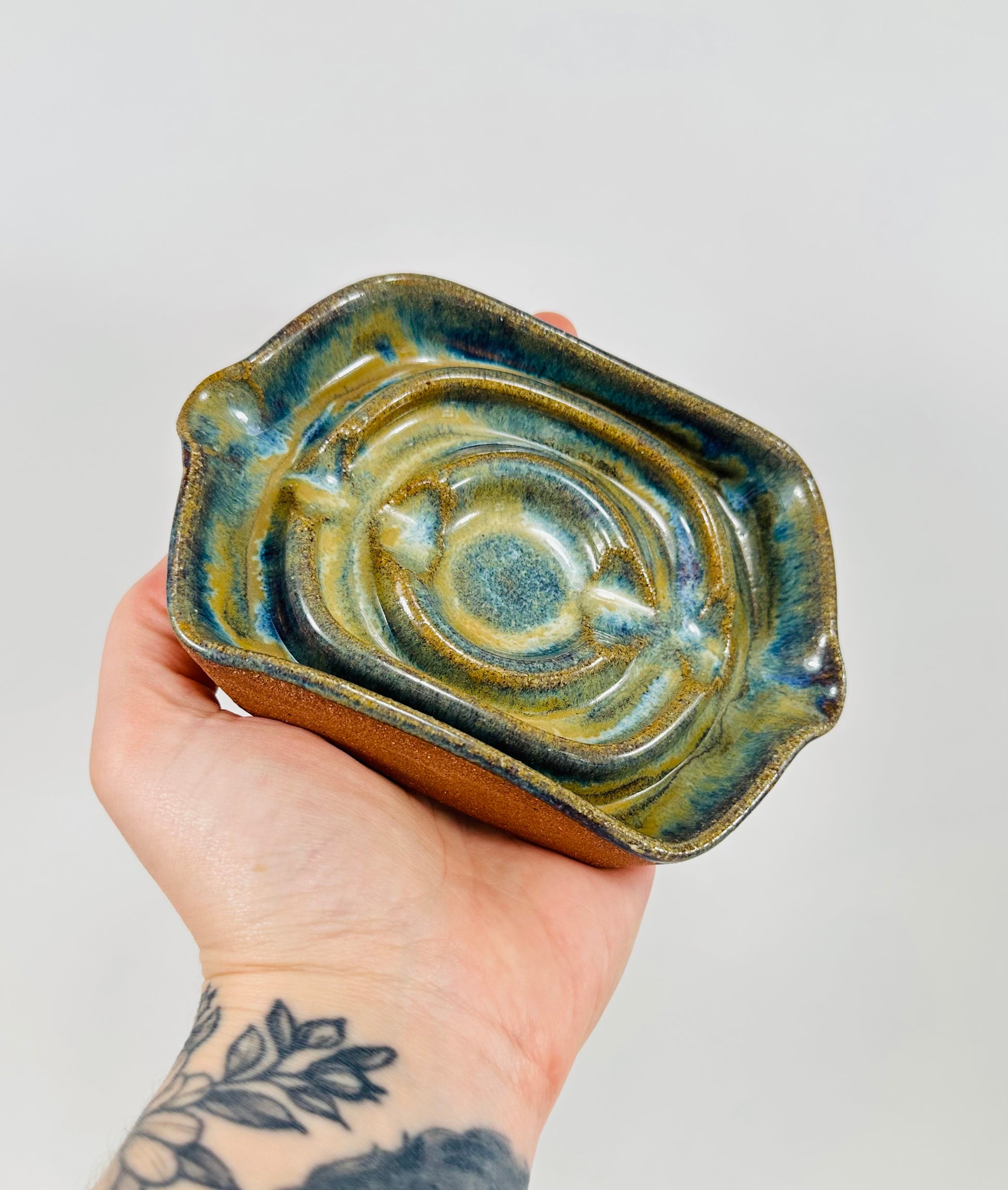 A handmade ceramic soap dish in a beautiful green glaze. The dish is made from red clay.