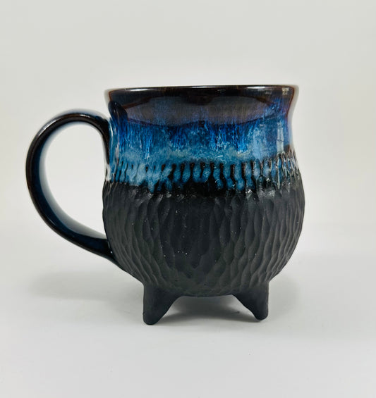 A handmade ceramic cauldron in a beautiful blue and black glaze.