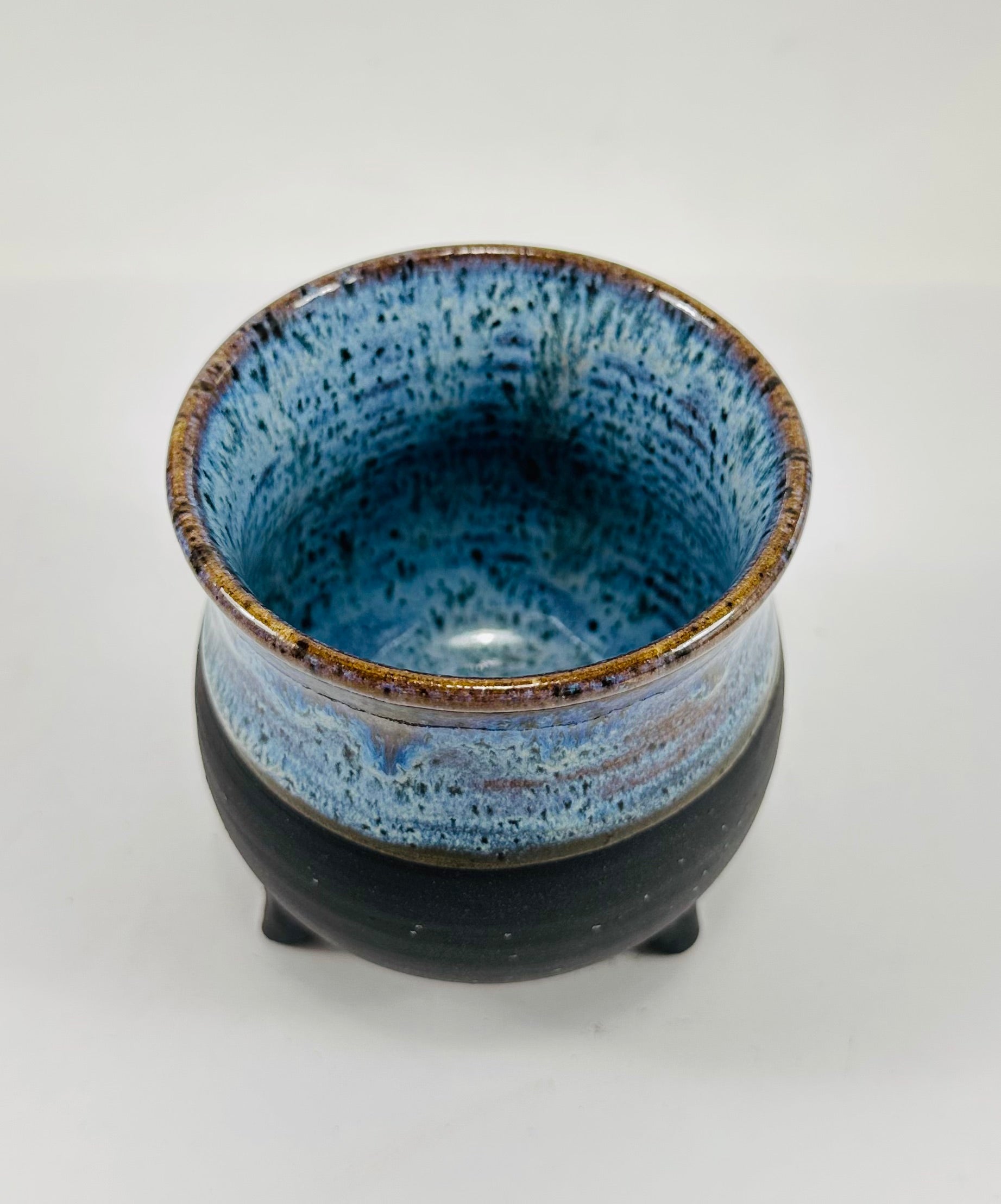 A handmade ceramic cauldron in a beautiful blue and black glaze.