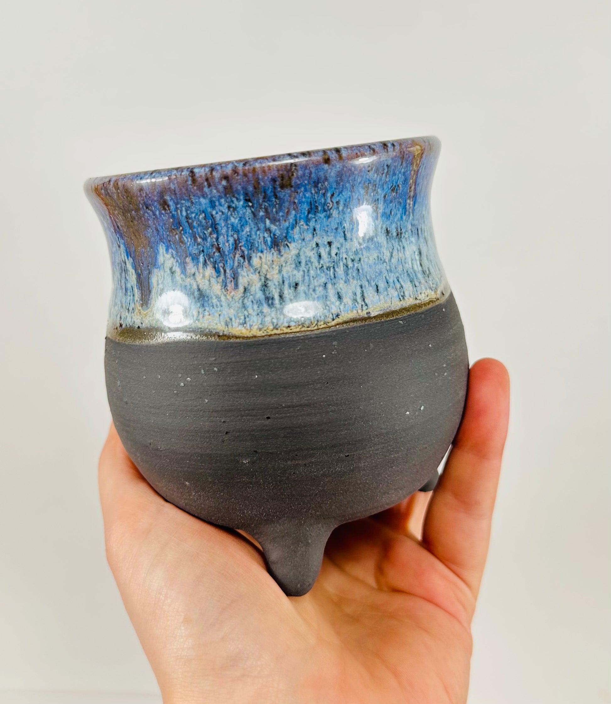 A handmade ceramic cauldron in a beautiful blue and black glaze.