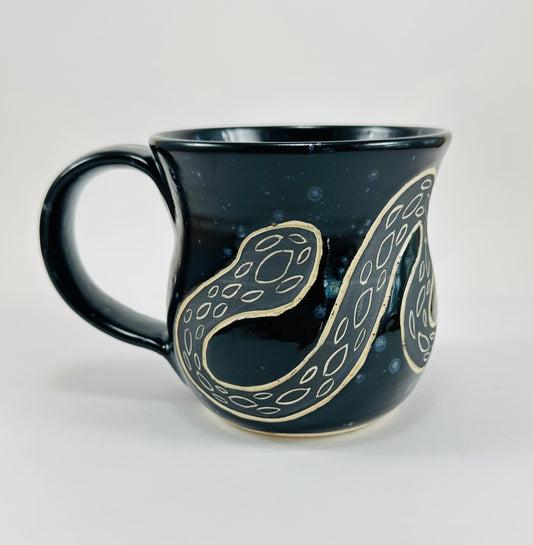 Black mug with snake design on a white background