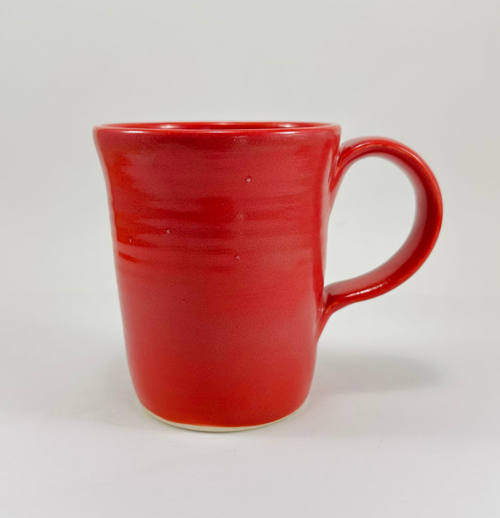 Pink mug with a green frog design on a white background
