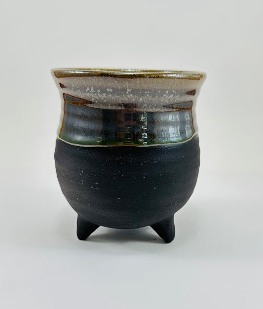 A handmade ceramic cauldron in a beautiful greenish brown glaze.