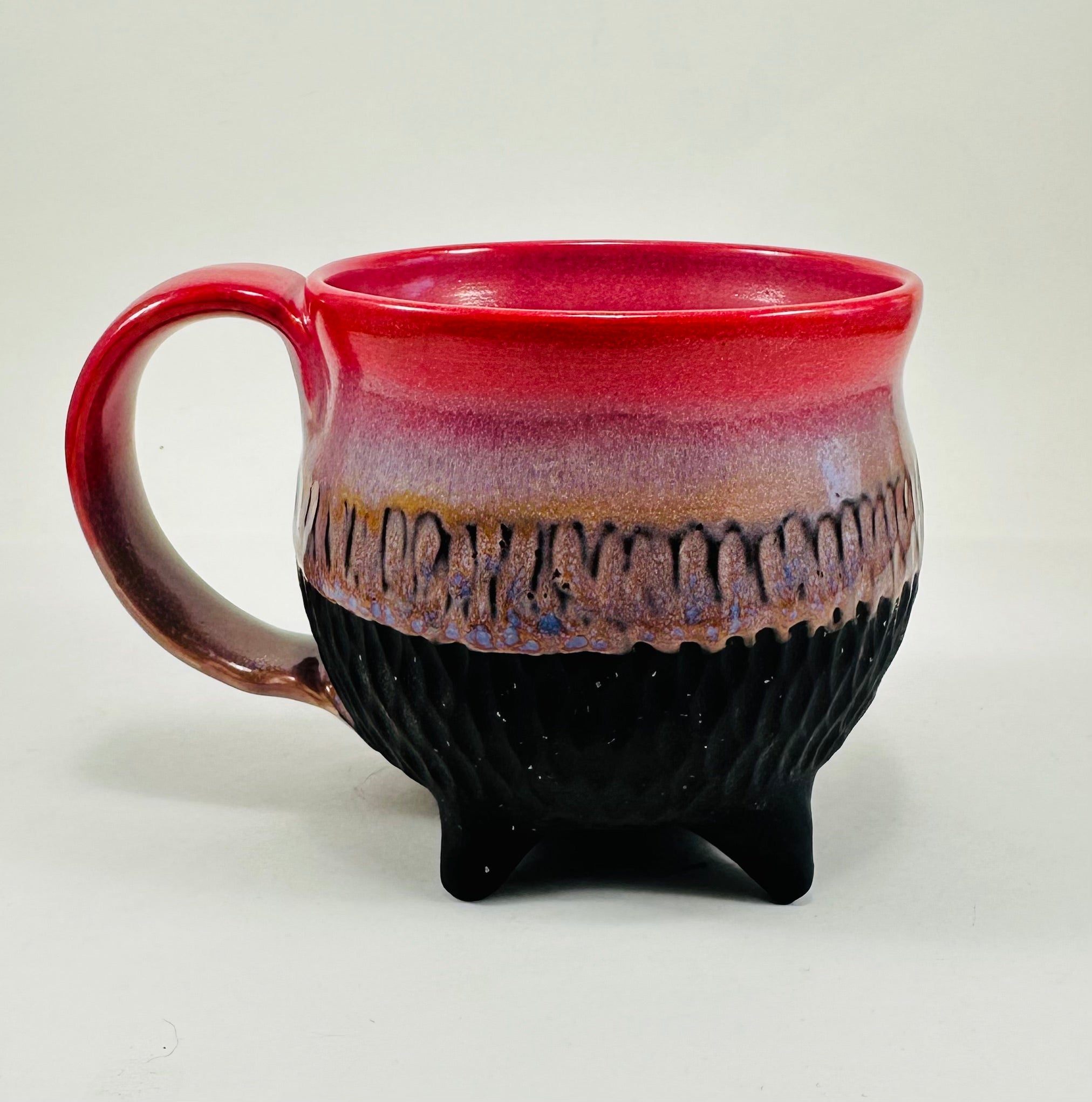 Handmade ceramic cauldron mug in a beautiful pink, purple and black glaze.