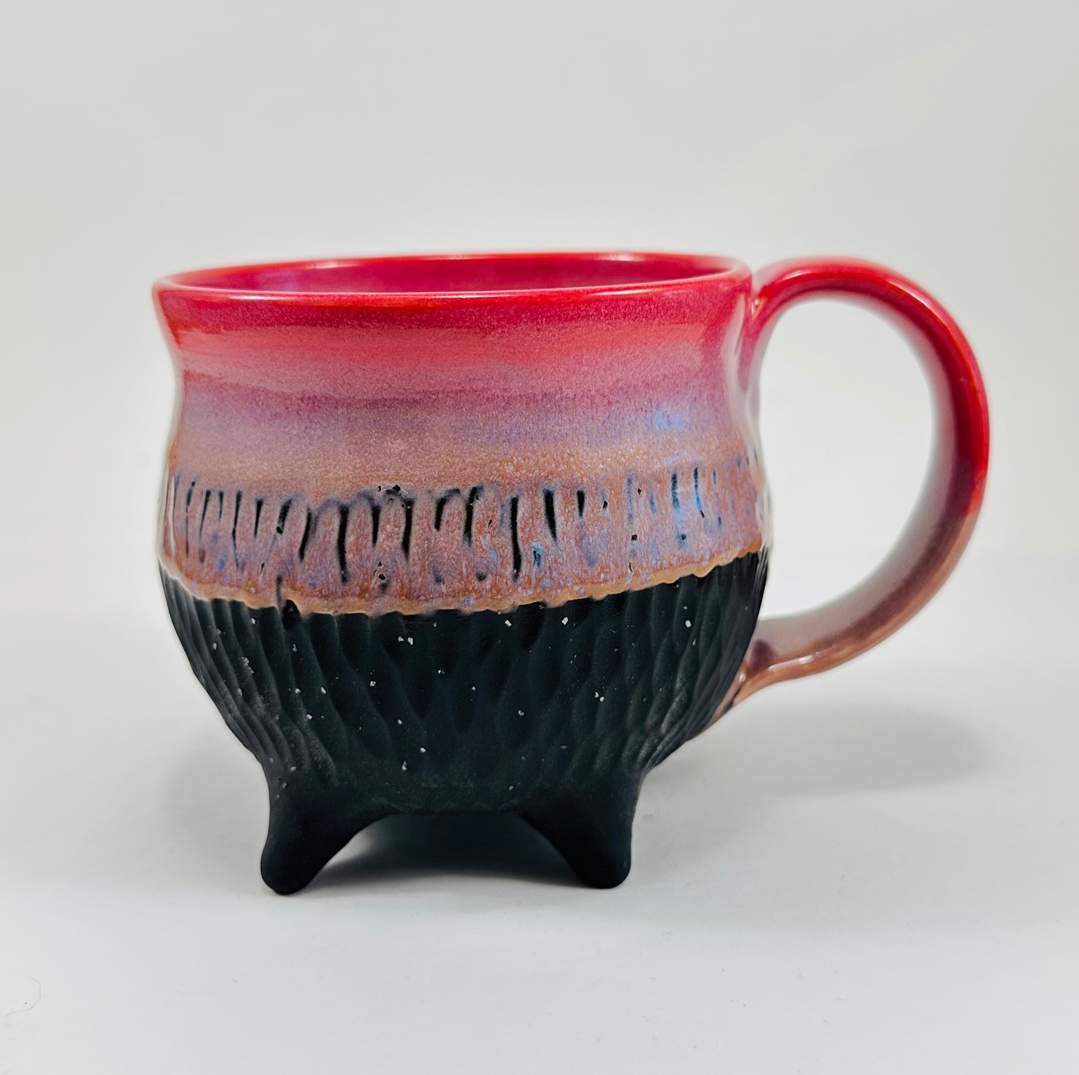 Handmade ceramic cauldron mug in a beautiful pink, purple and black glaze.