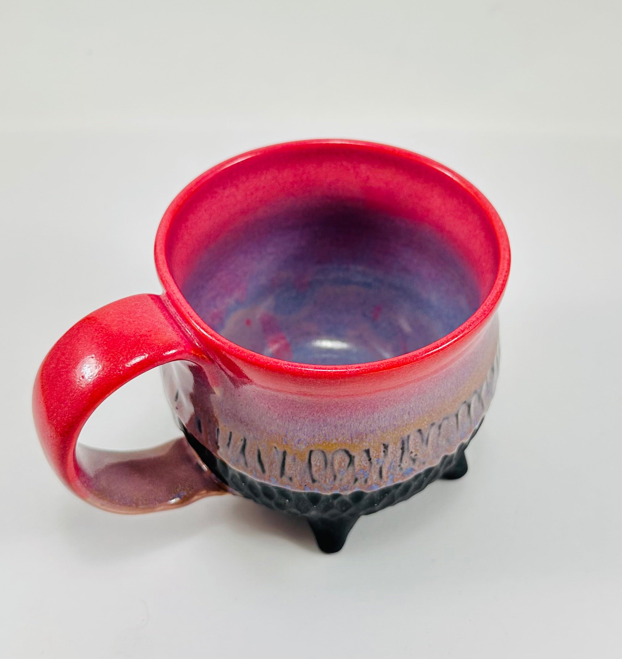 Handmade ceramic cauldron mug in a beautiful pink, purple and black glaze.