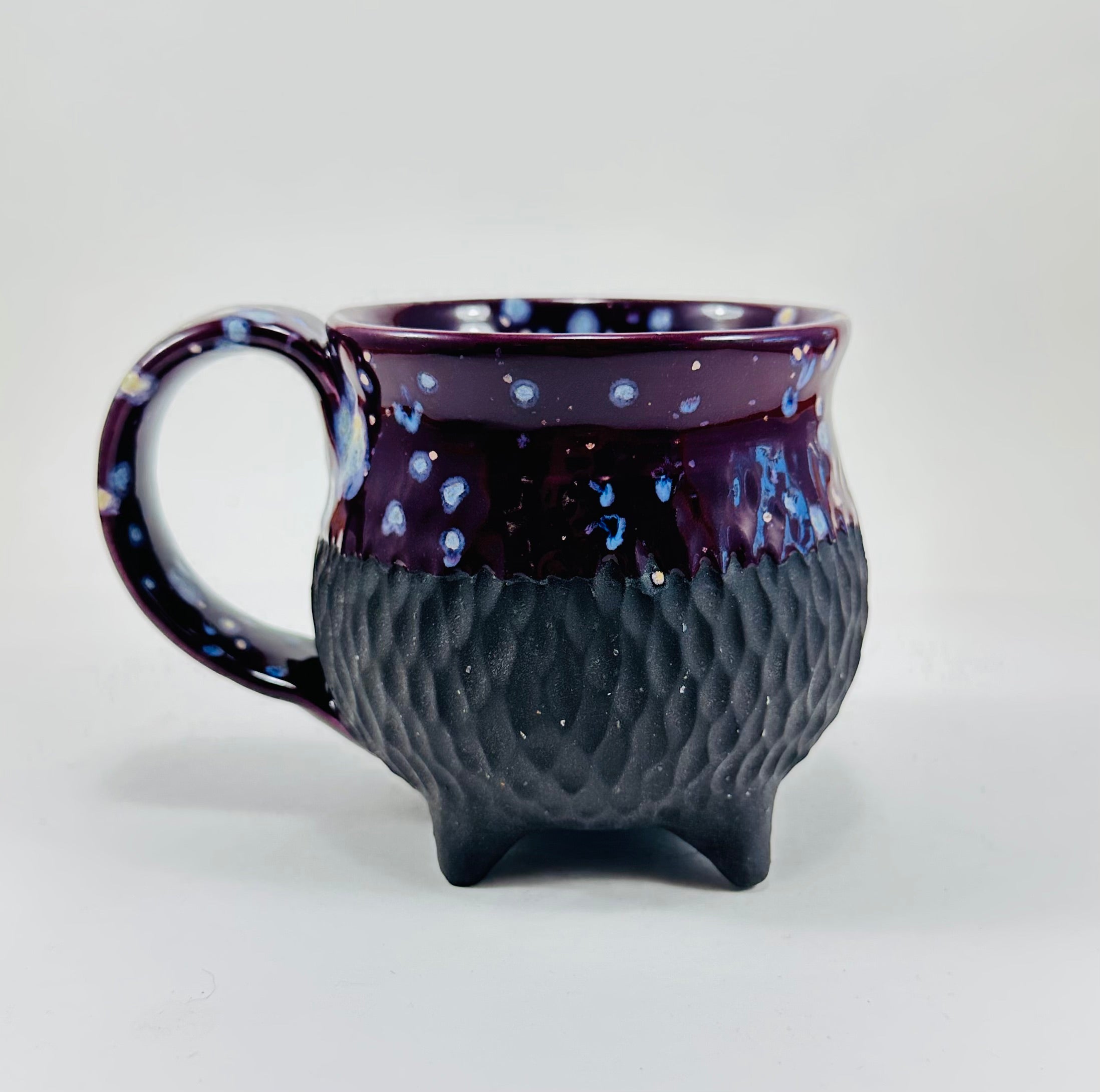Handmade ceramic cauldron mug in a beautiful purple and black glaze.