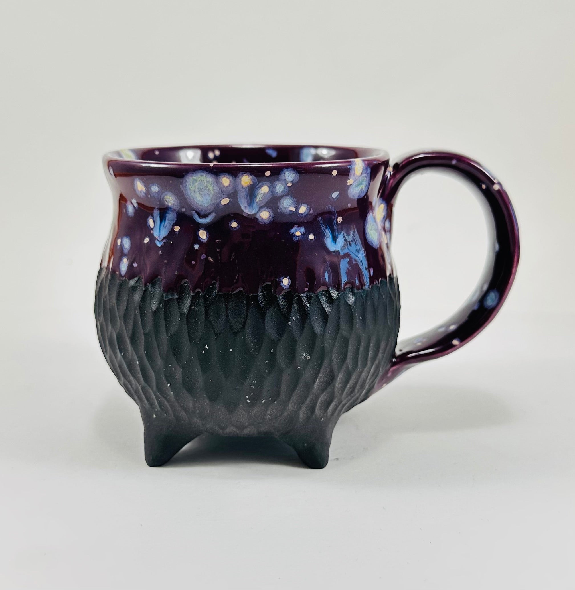 Handmade ceramic cauldron mug in a beautiful purple and black glaze.