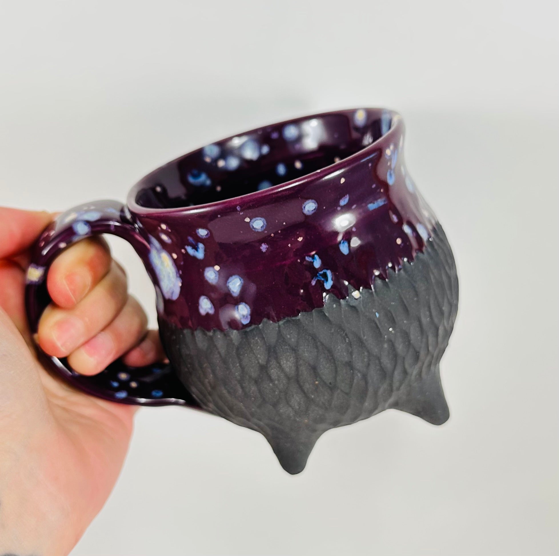 Handmade ceramic cauldron mug in a beautiful purple and black glaze.