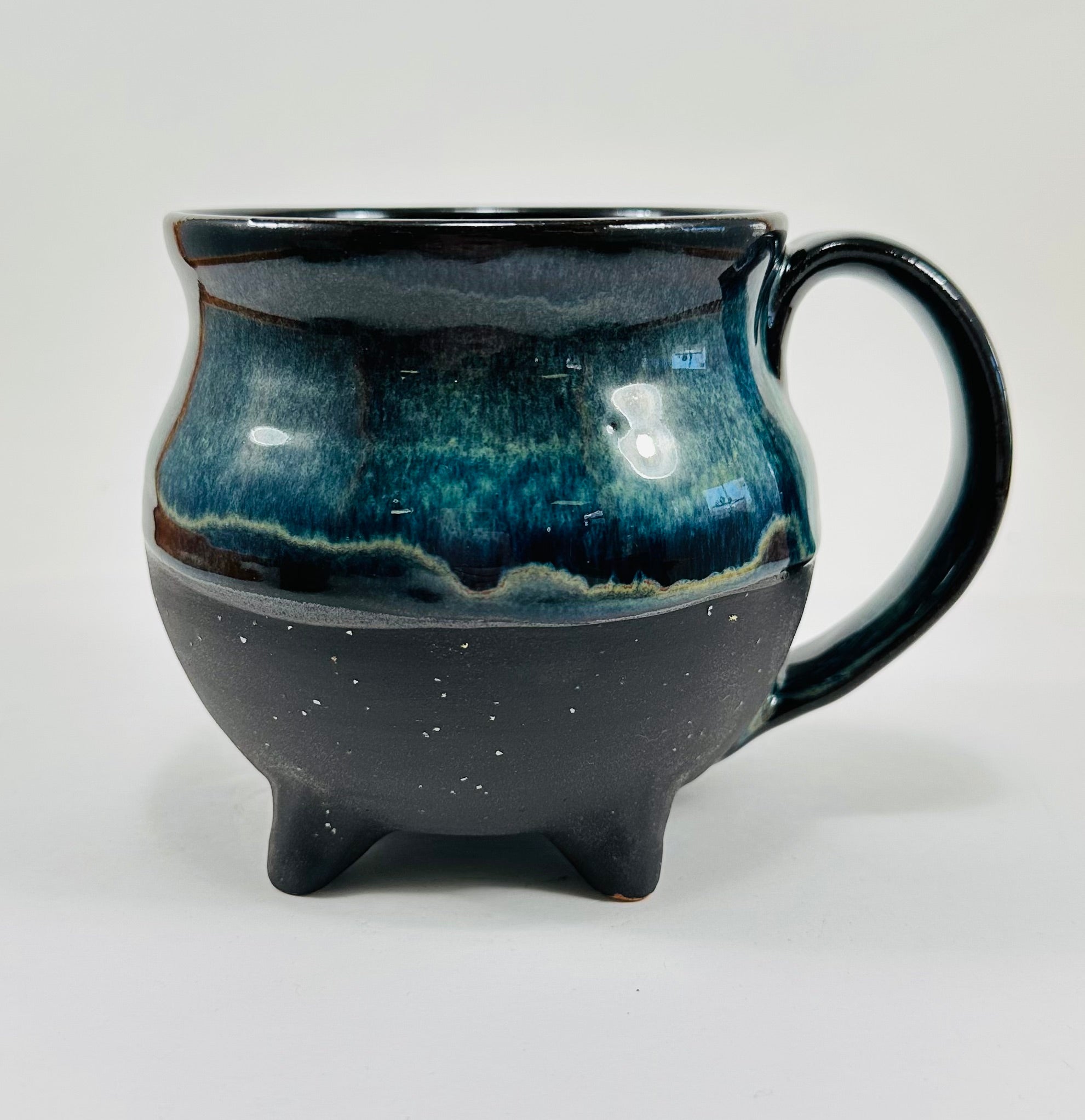 Handmade cauldron mug in a beautiful blue and black glaze.