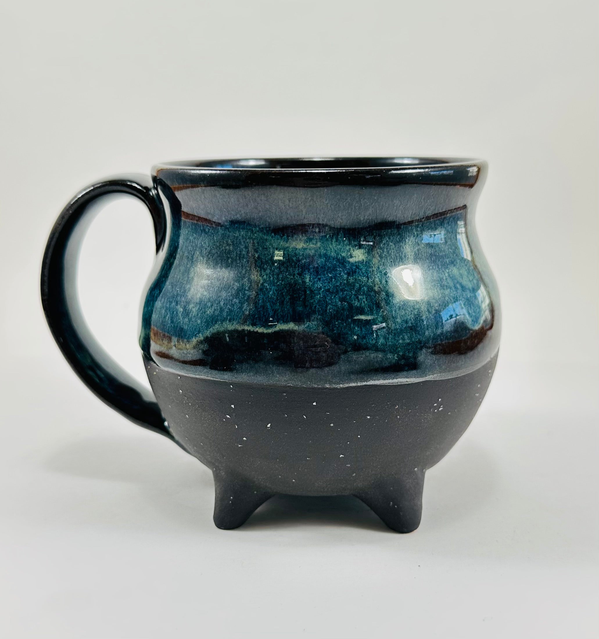 Handmade cauldron mug in a beautiful blue and black glaze.