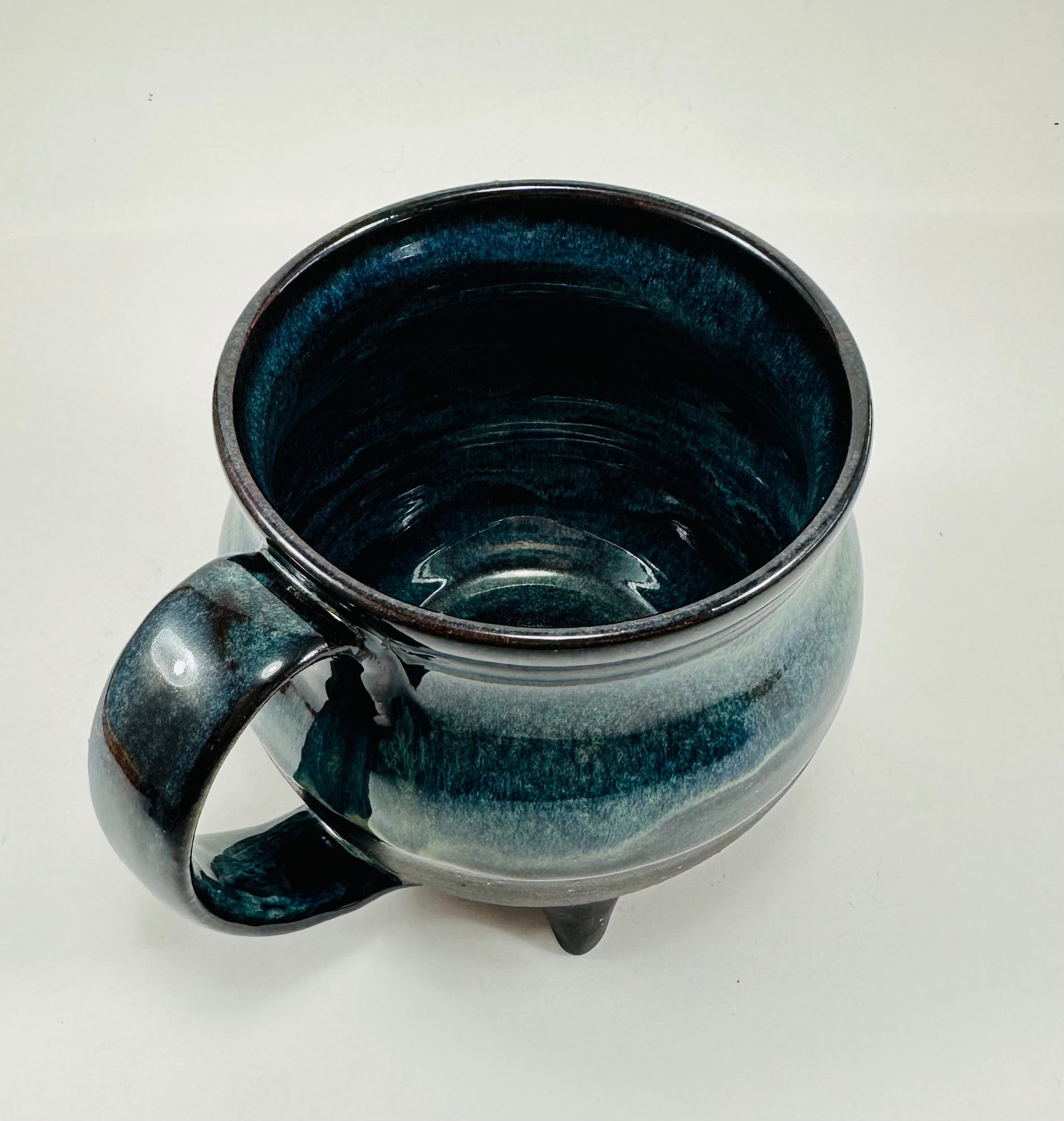 Handmade cauldron mug in a beautiful blue and black glaze.