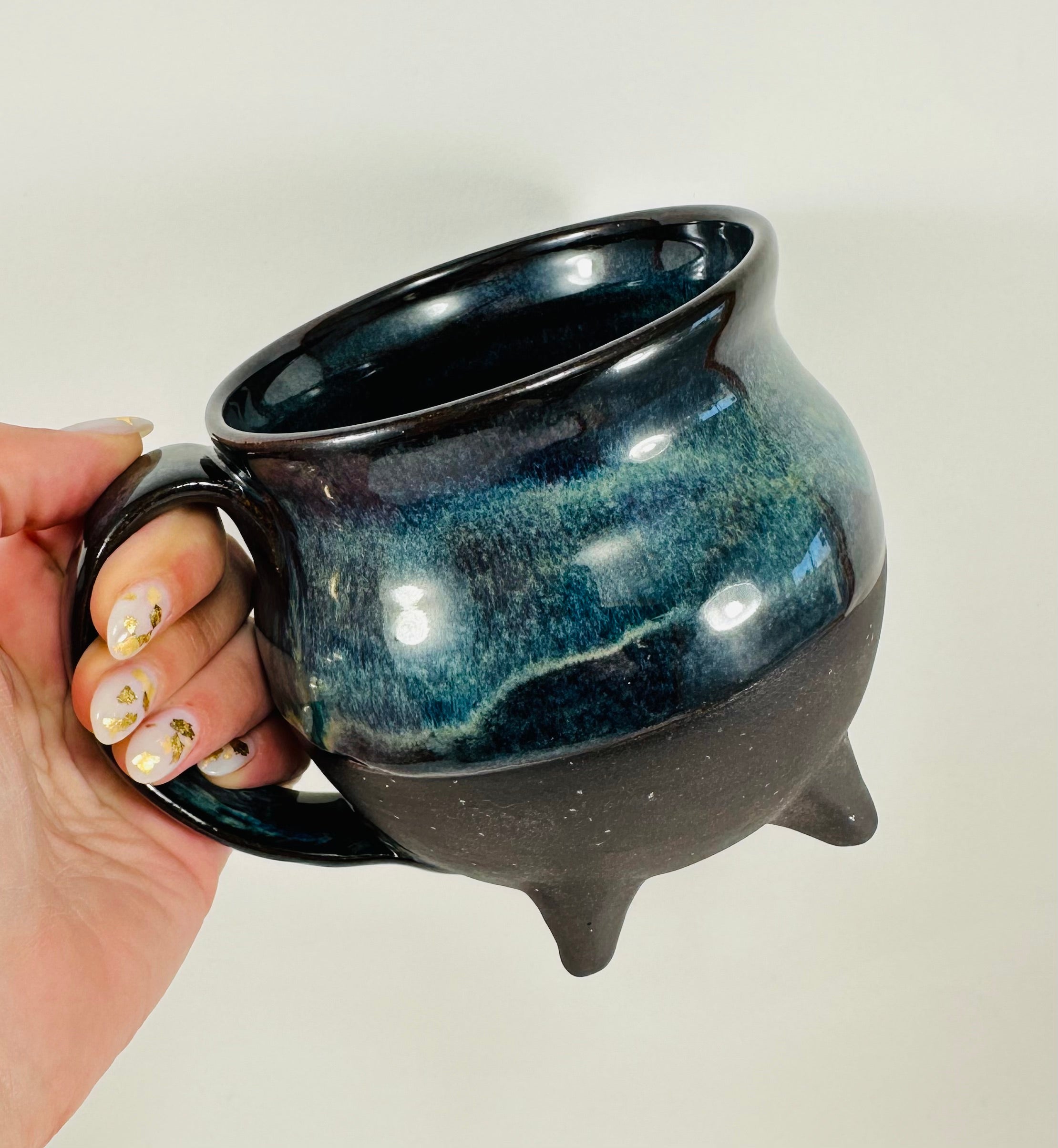 Handmade cauldron mug in a beautiful blue and black glaze.