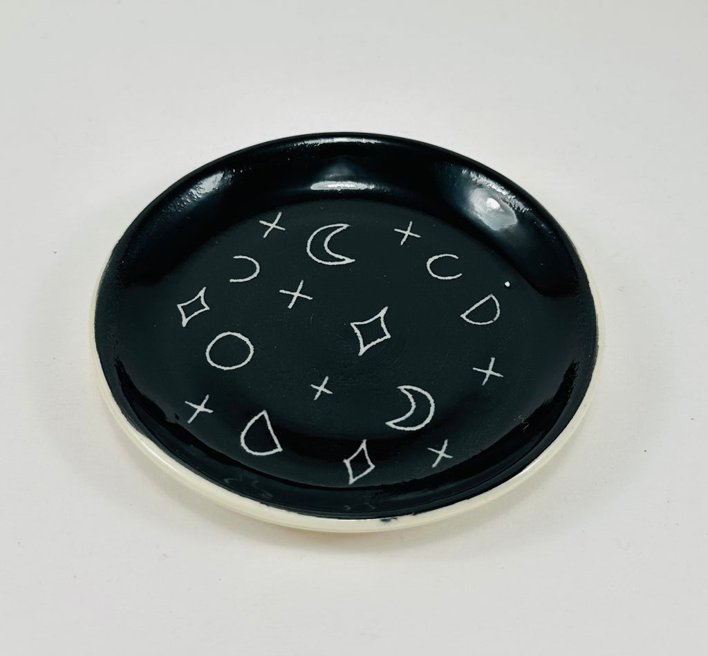 Handmade trinket dish in  black and white glaze with moons and stars.