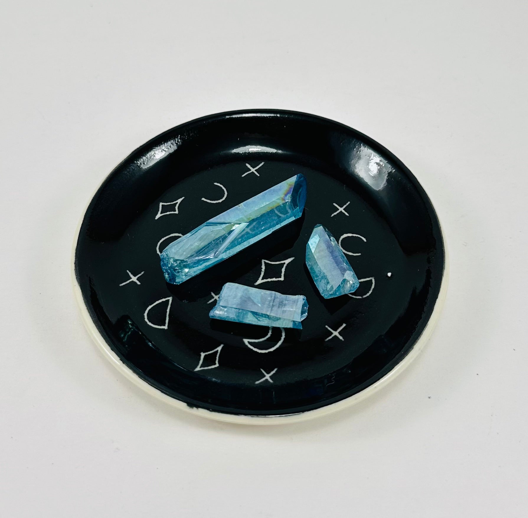 Handmade trinket dish in  black and white glaze with moons and stars.
