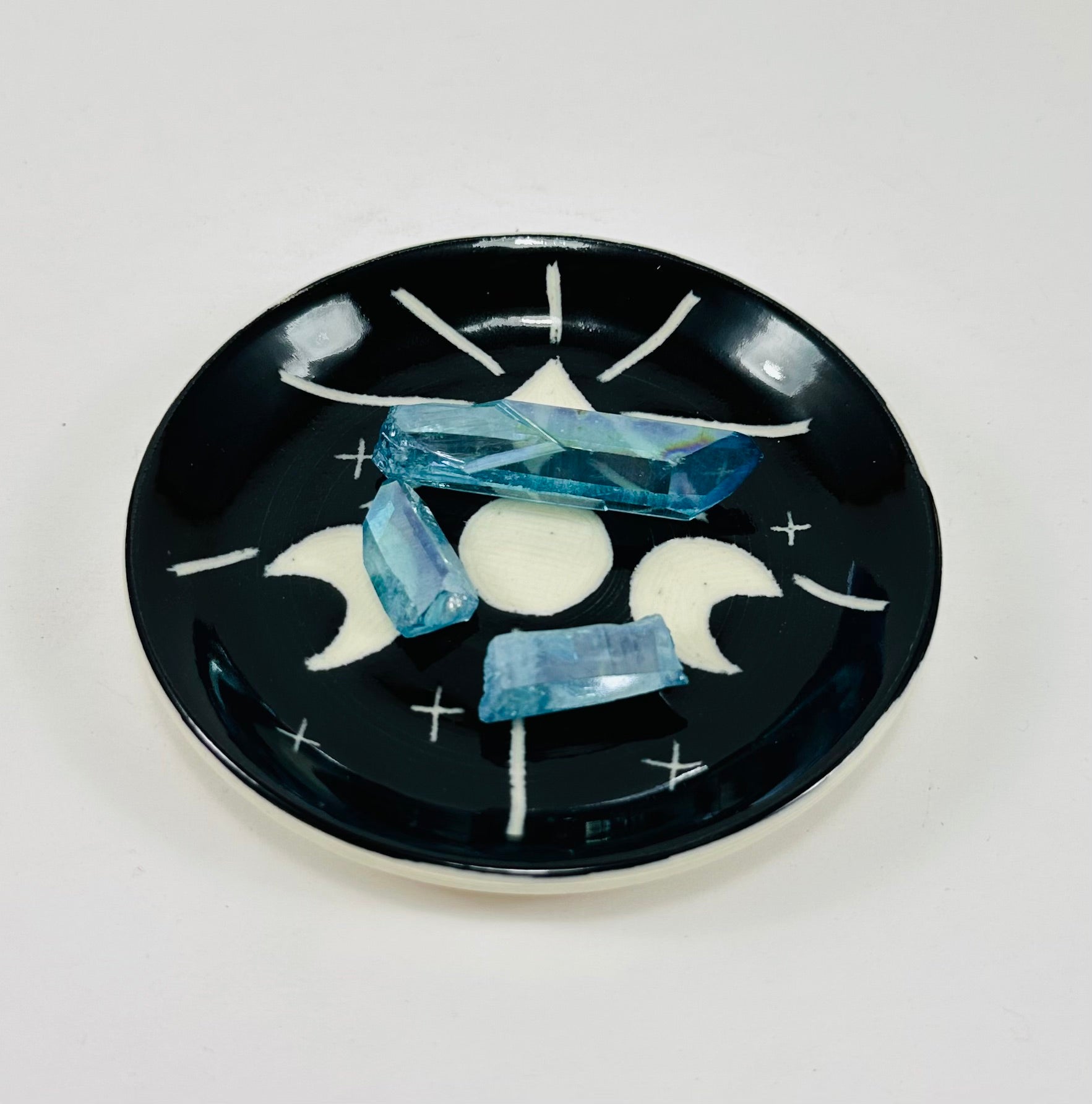 Handmade trinket dish in  black and white glaze with moons and stars.