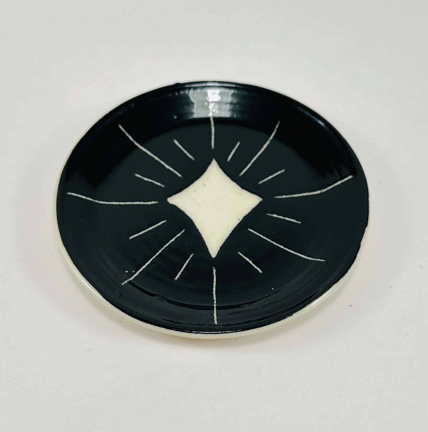 Handmade trinket dish in  black and white glaze with stars.